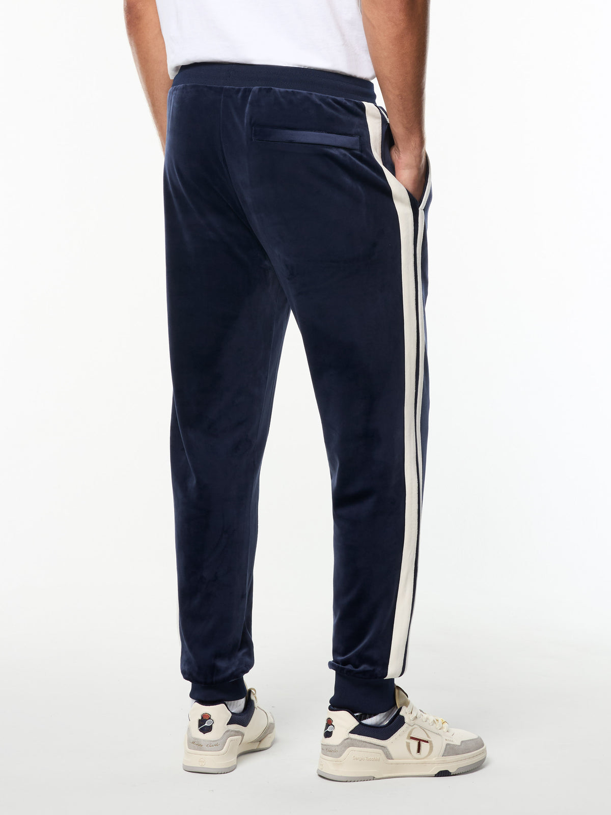 Back view of the Damarindo Velour Track Pant in Maritime Blue, showing the zip back pocket and side stripes.