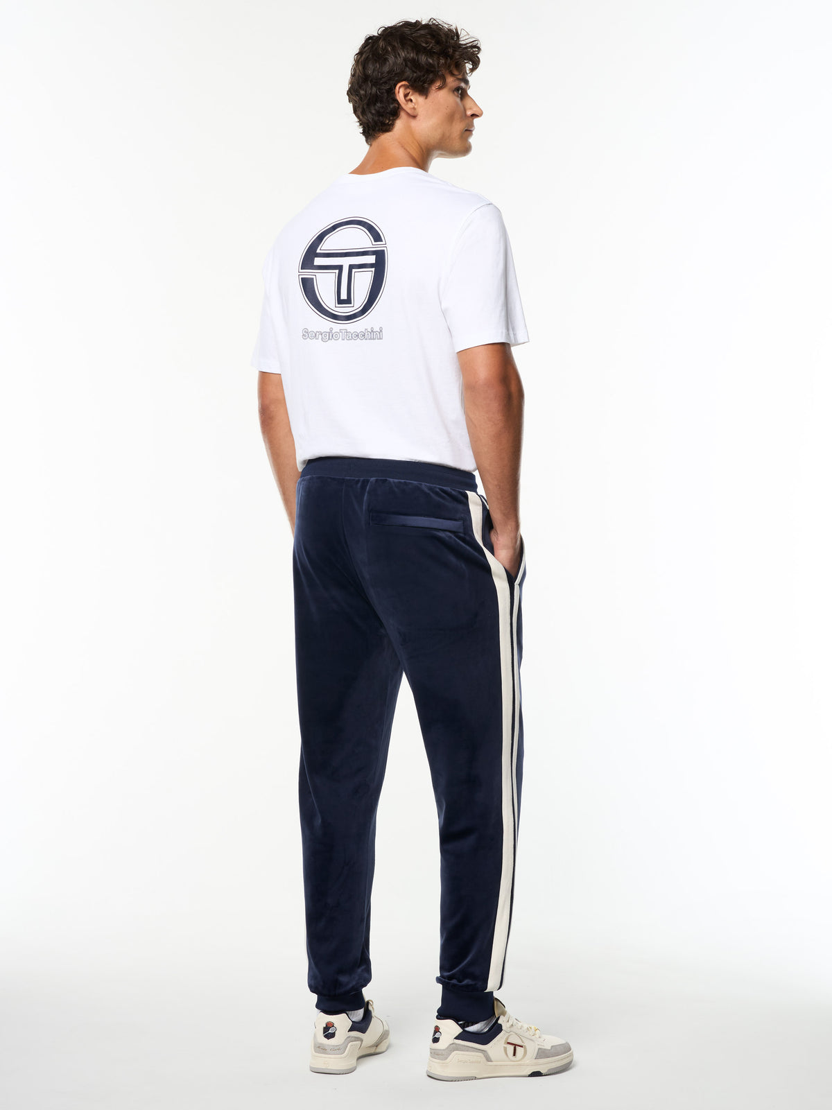 Full body back view of the Damarindo Velour Track Pant in Maritime Blue with a white Sergio Tacchini logo tee.