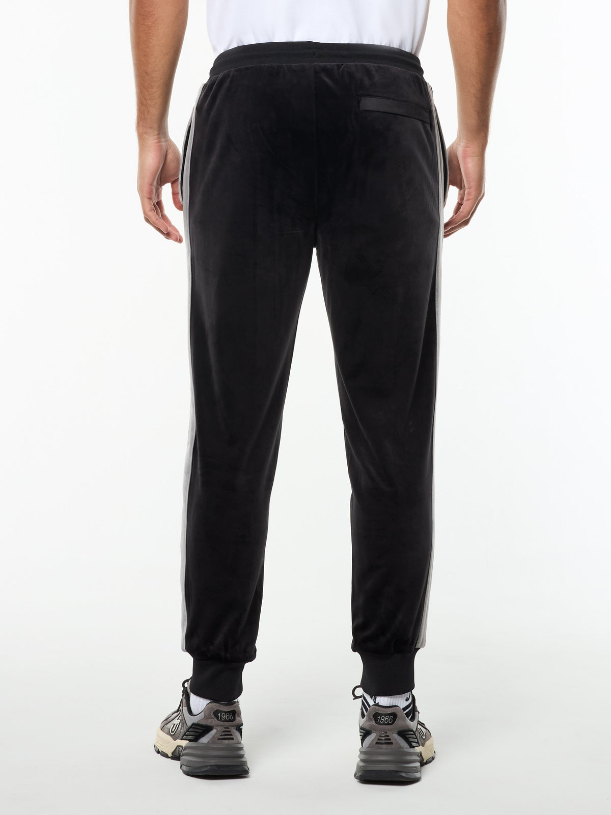 Back view of the Damarindo Velour Track Pant in Black Beauty, showing the zip back pocket and ribbed cuffs.