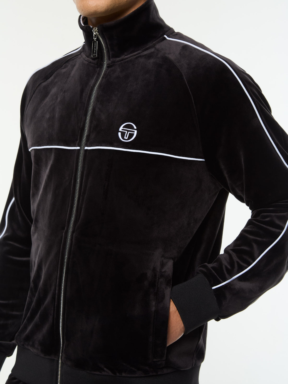 Close-up of the chest logo, zip and piping on the Lioni Velour Track Jacket in Black Beauty.