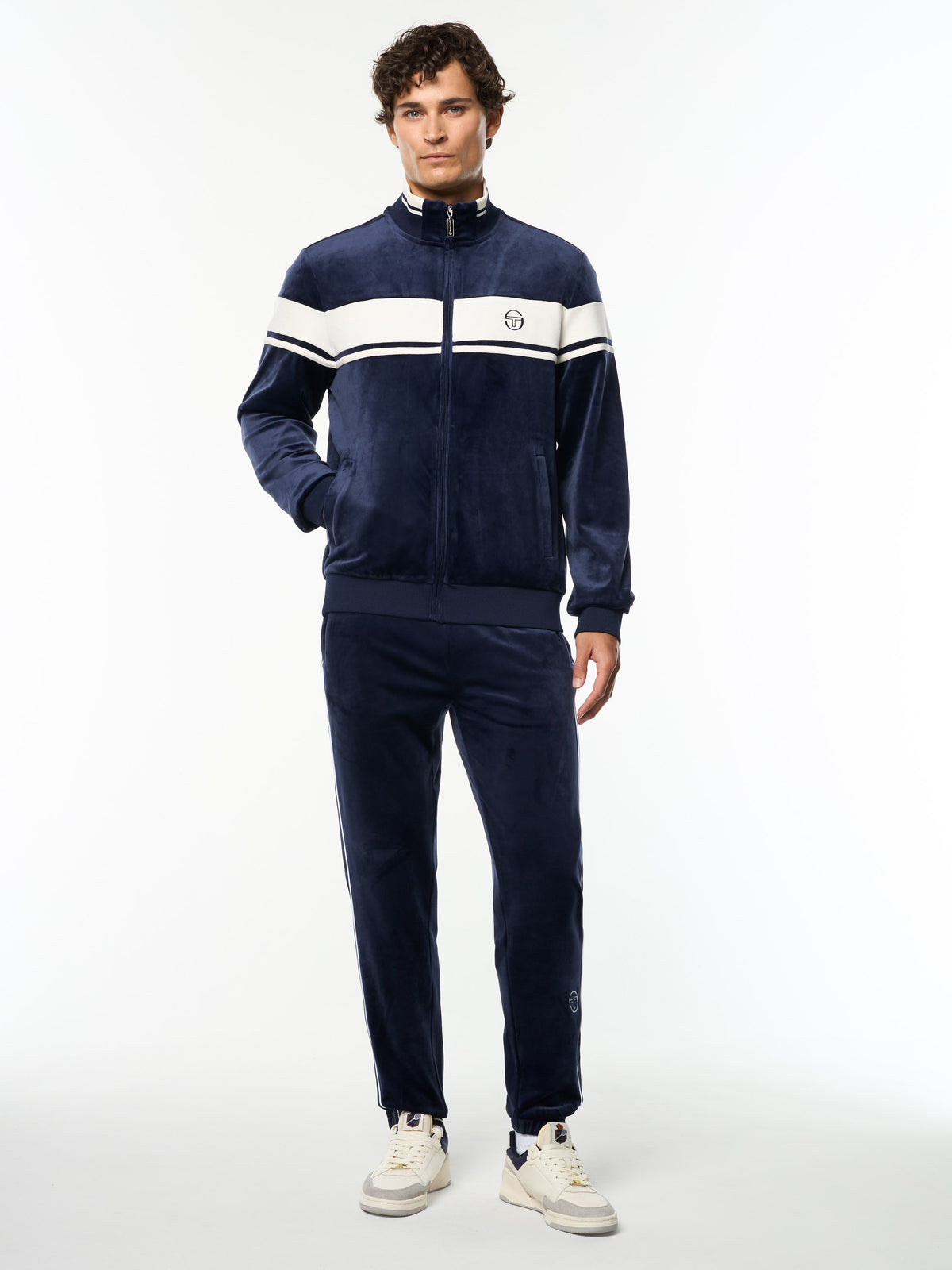 Model wearing the Damarindo Velour Track Jacket and matching pants in Maritime Blue, full body front view.