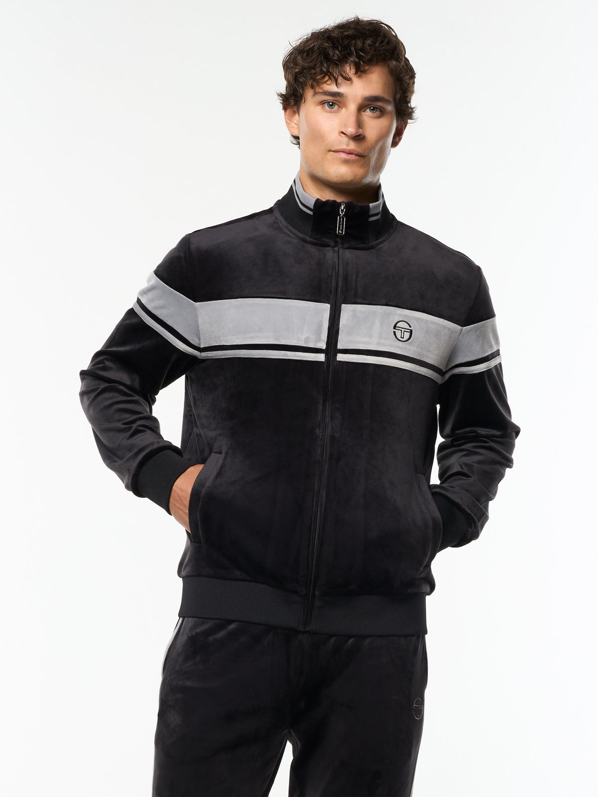 Model wearing the Damarindo Velour Track Jacket in Black Beauty with a gray chest stripe, front upper body view.