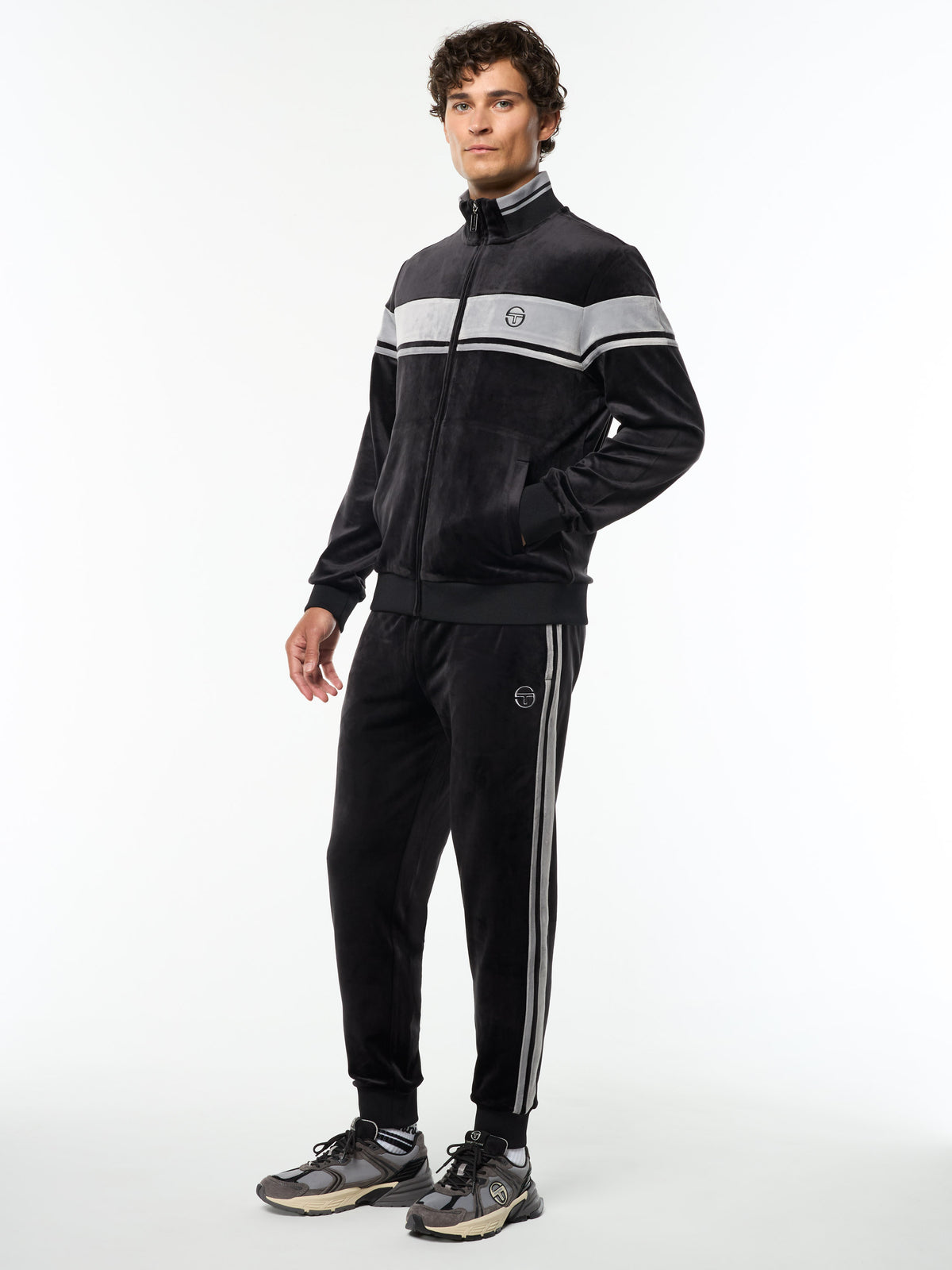 Full body angled view of the Damarindo Velour Track Jacket and matching pants in Black Beauty.