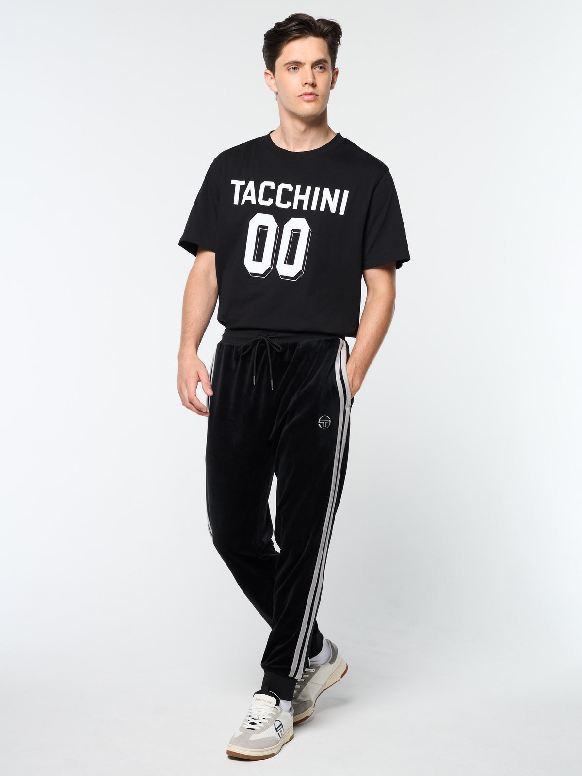 Model wearing the Damarindo Velour Track Pant in Black Beauty with a Tacchini graphic t-shirt.