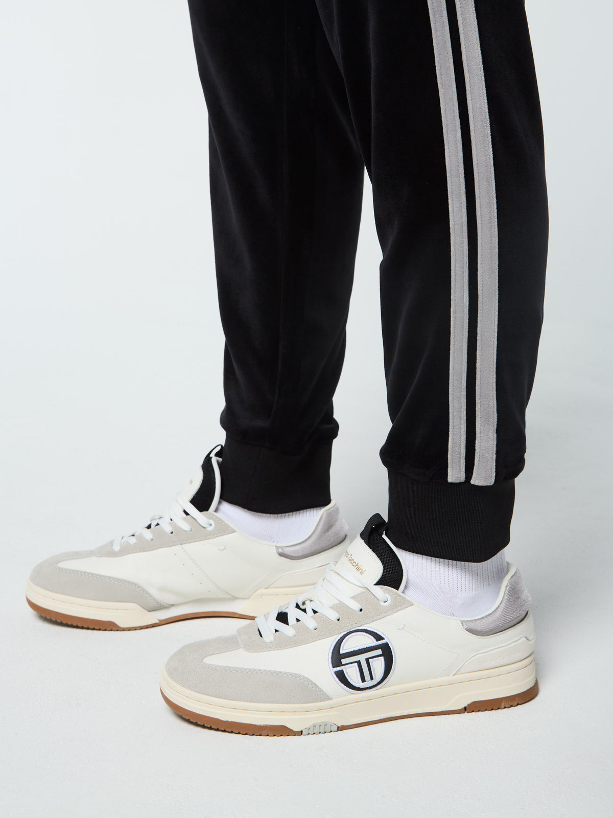 Close-up of the ankle hem and side stripe on the Damarindo Velour Track Pant in Black Beauty.