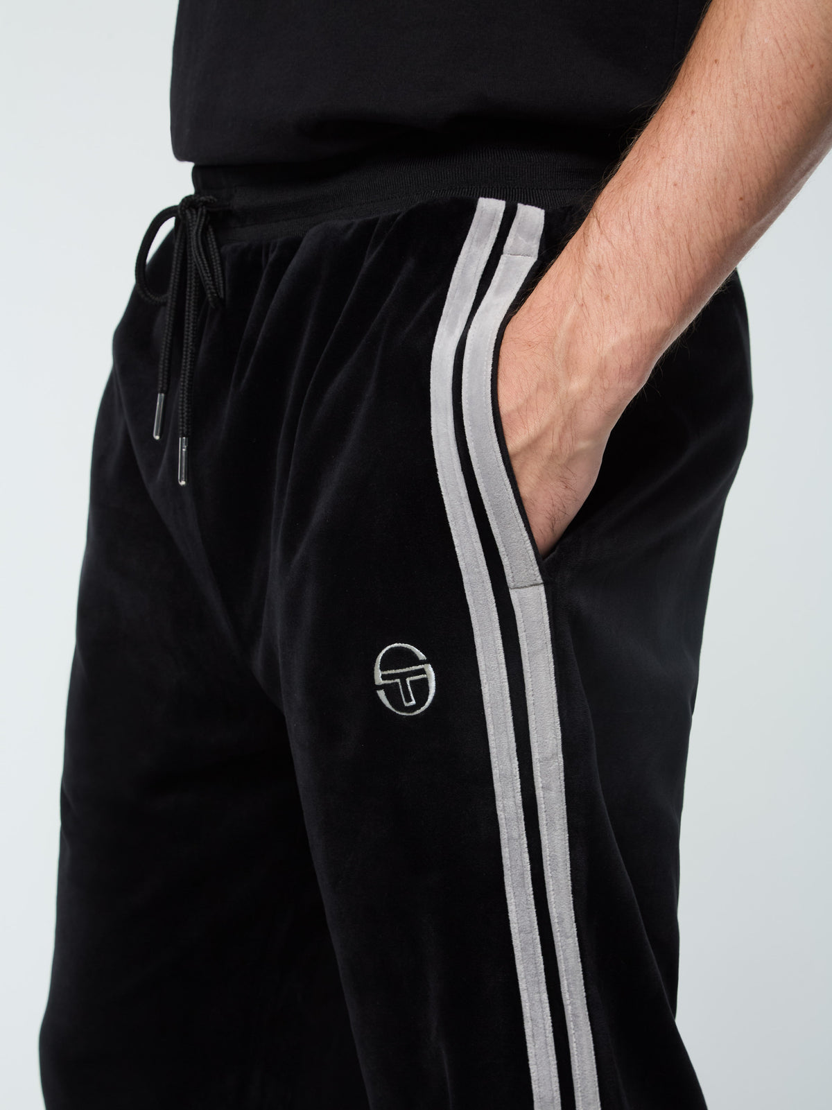 Close-up of the drawstring waistband and Sergio Tacchini logo on the Damarindo Velour Track Pant in Black Beauty.
