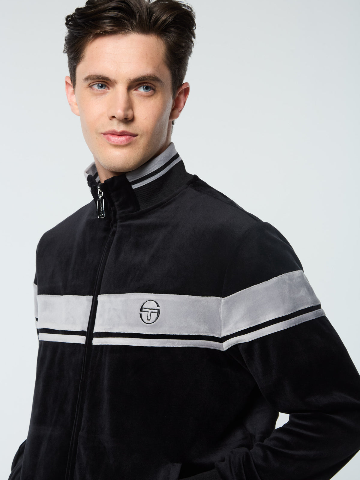 Close-up of the Sergio Tacchini logo and chest stripe on the Damarindo Velour Track Jacket in Black Beauty.