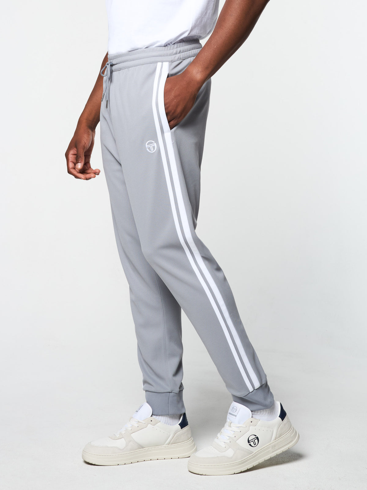 Damarindo Track Pant Archivio in Sleet/White, cropped side view with white side stripe, worn with a white tee.
