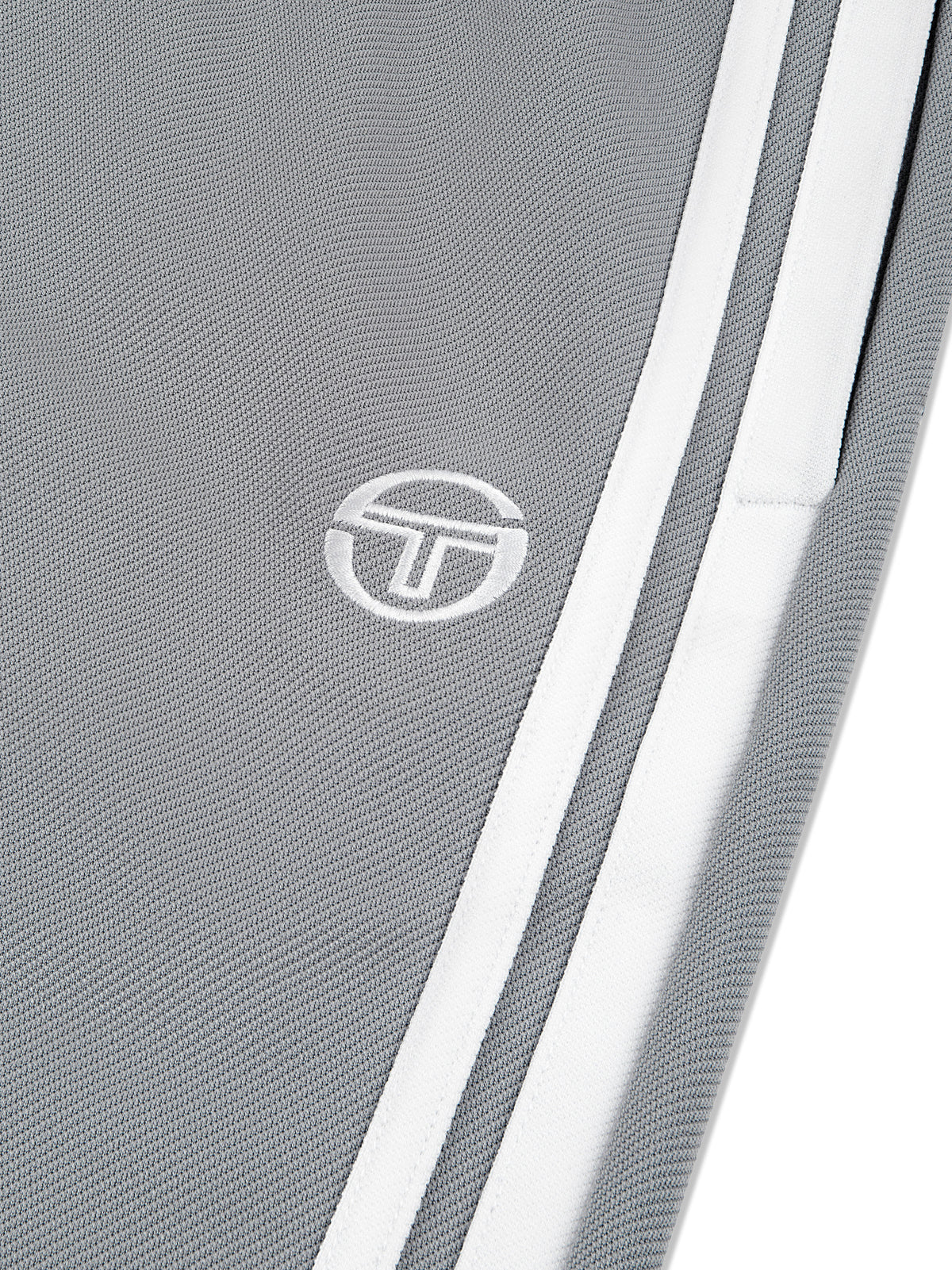 Close-up of the embroidered logo and double side stripe on the Damarindo Track Pant Archivio in Sleet/White.