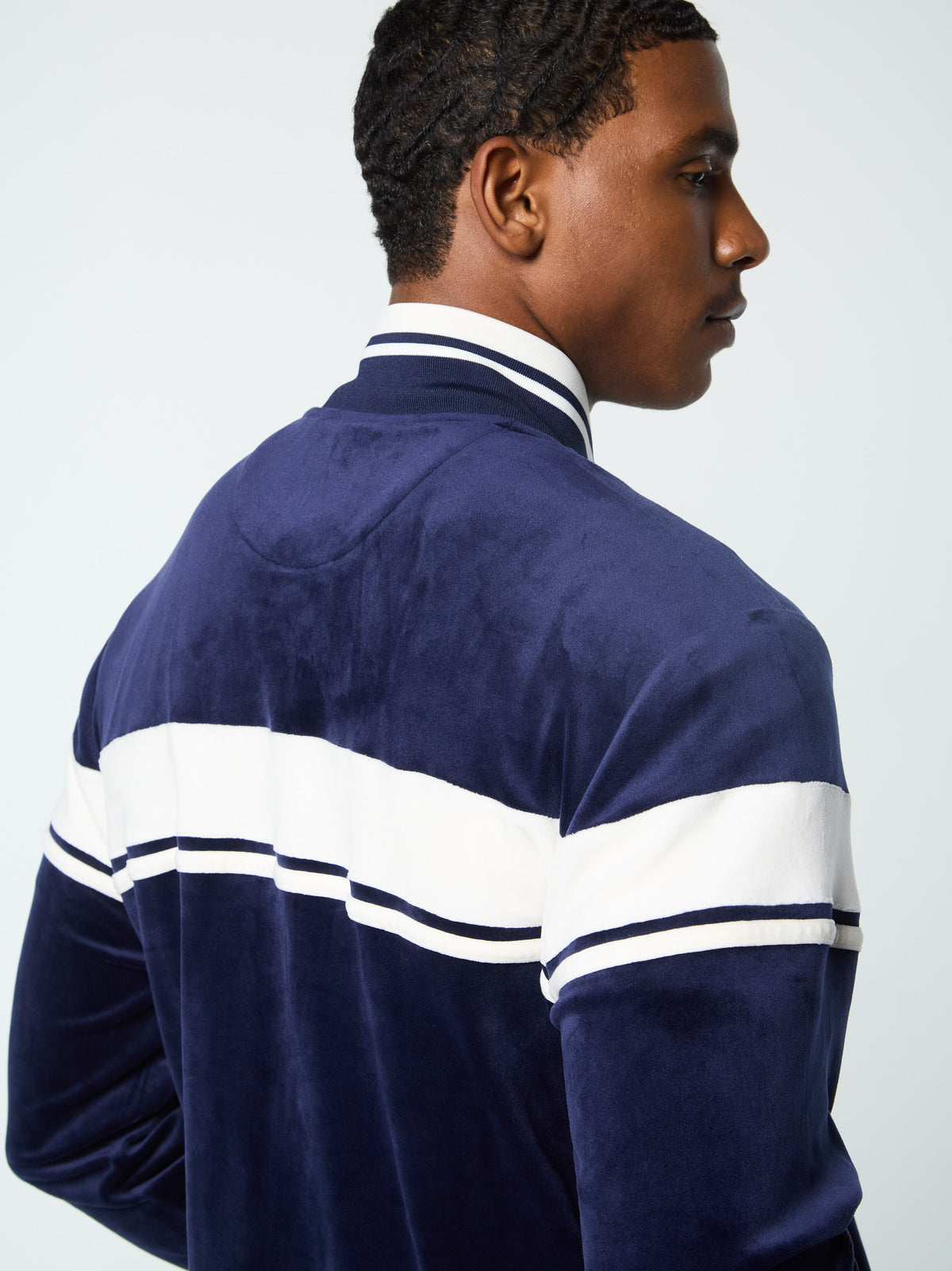 Close-up back view of the collar and chest stripe on the Damarindo Velour Track Jacket in Maritime Blue.