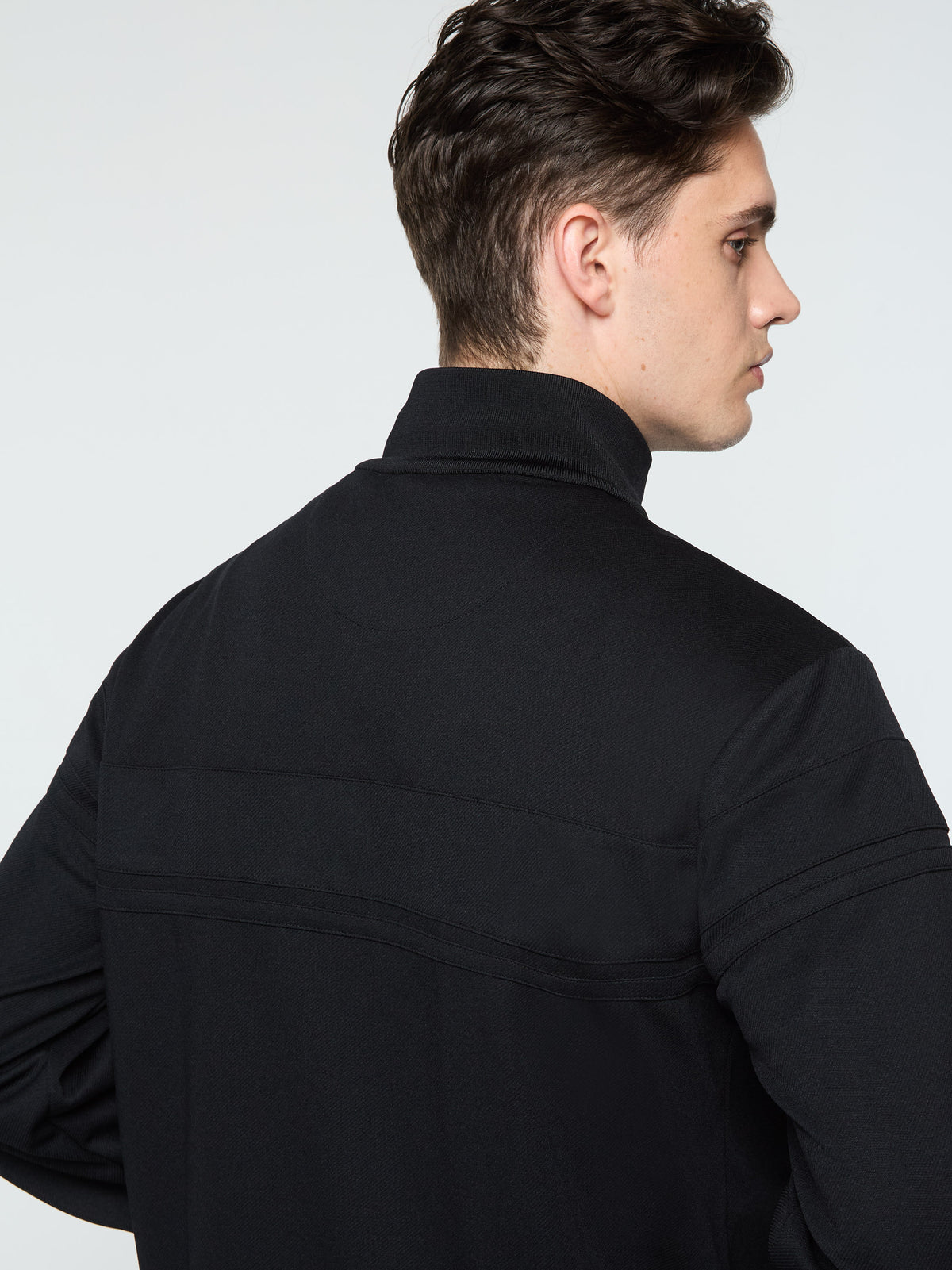 Close-up back view of the collar and seam detail on the Damarindo Track Jacket Archivio in Black.