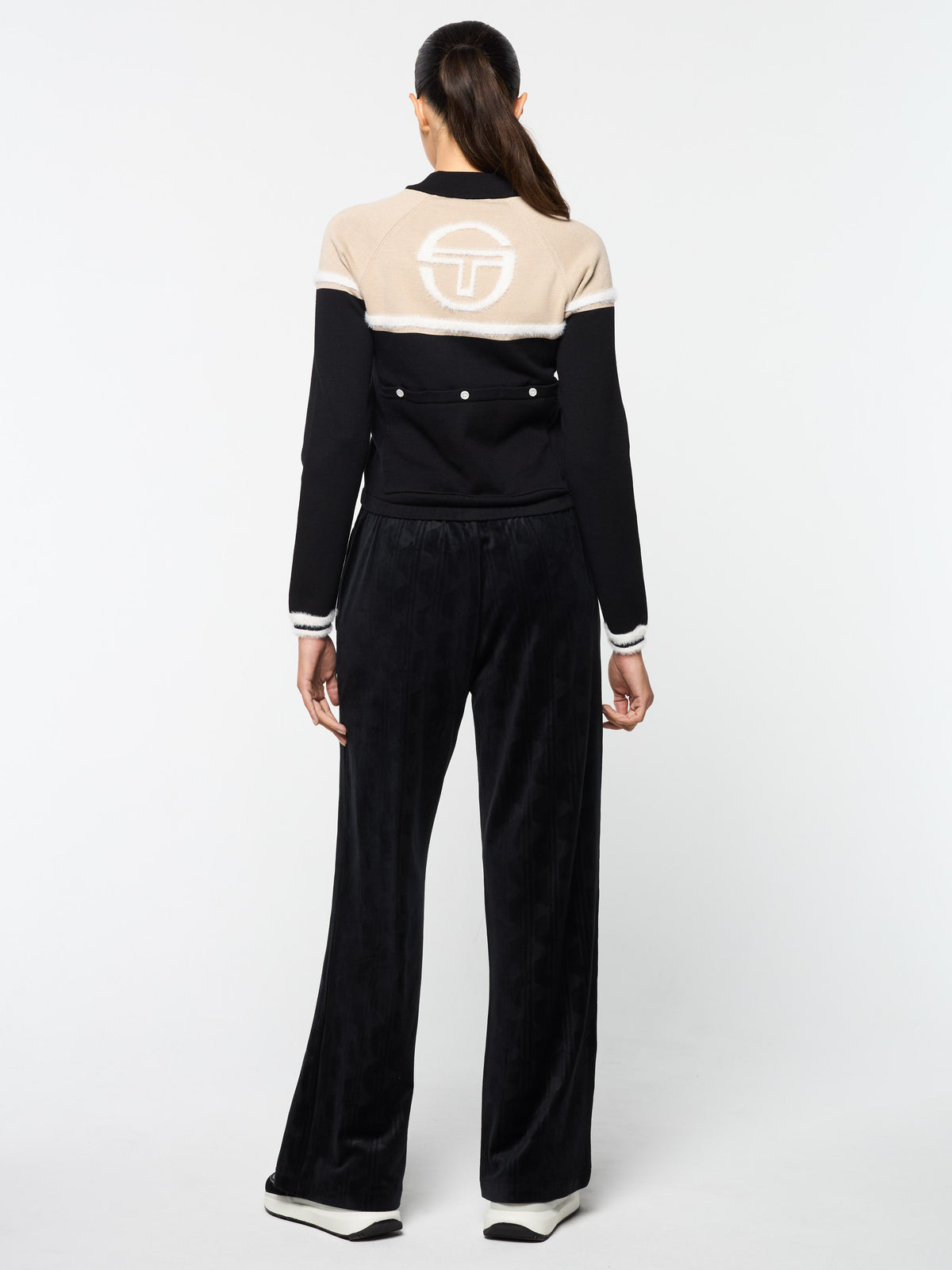 Full body back view of the Ruota Cycling Jersey in Black Beauty with wide-leg velour pants.