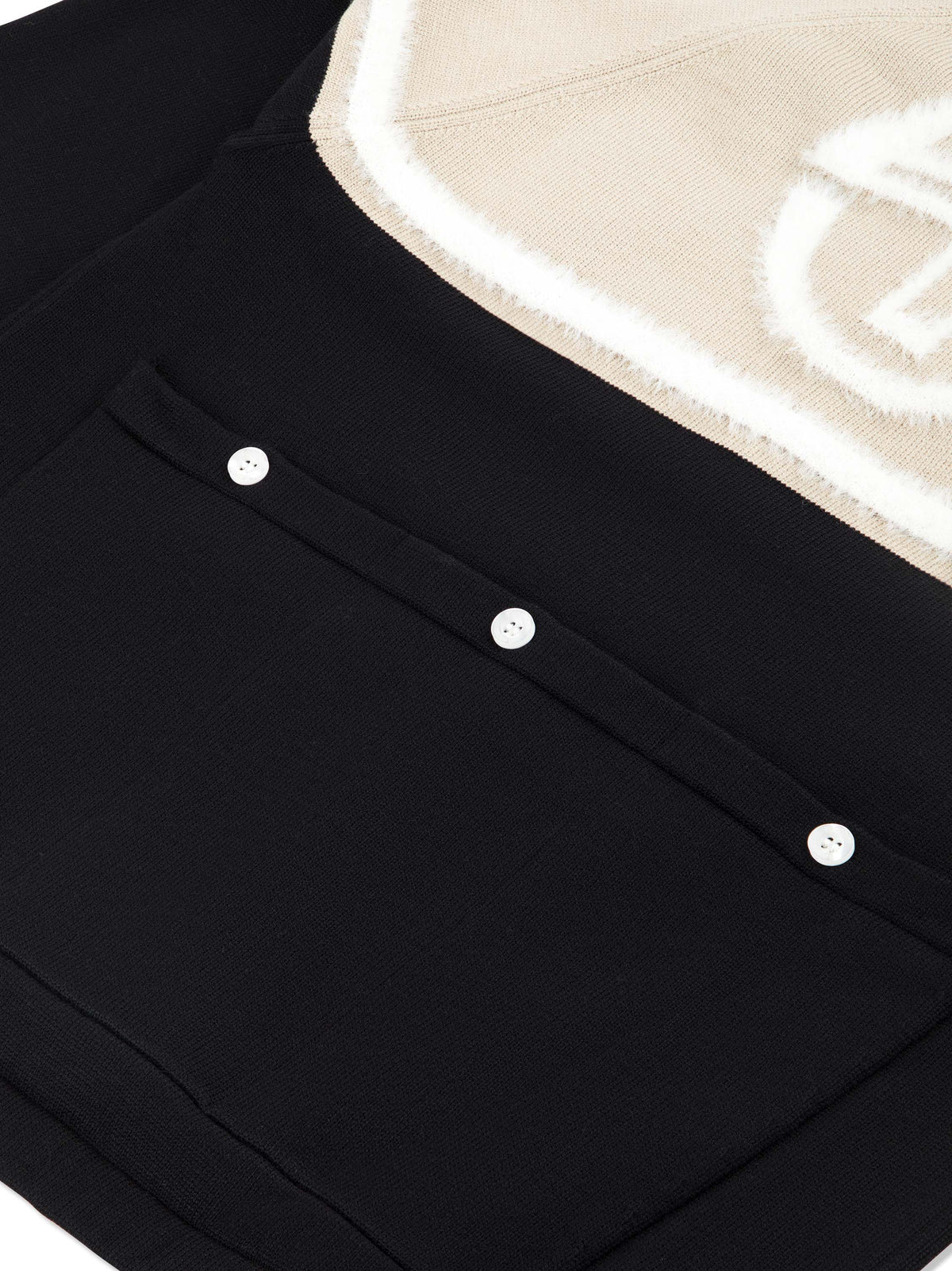 Close-up of the textured logo and buttoned back pocket on the Ruota Cycling Jersey in Black Beauty.