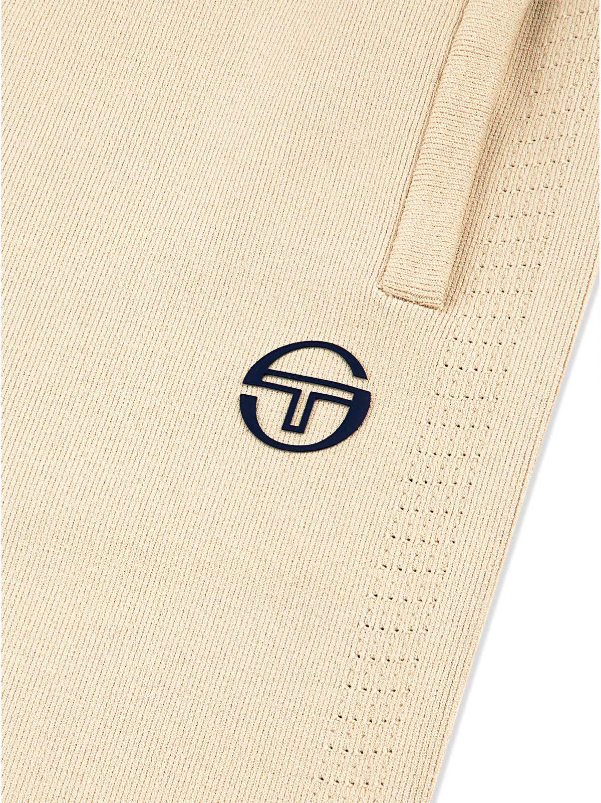 Close-up of the embroidered logo and perforated knit texture on the Rosolina Track Pant in Humus.