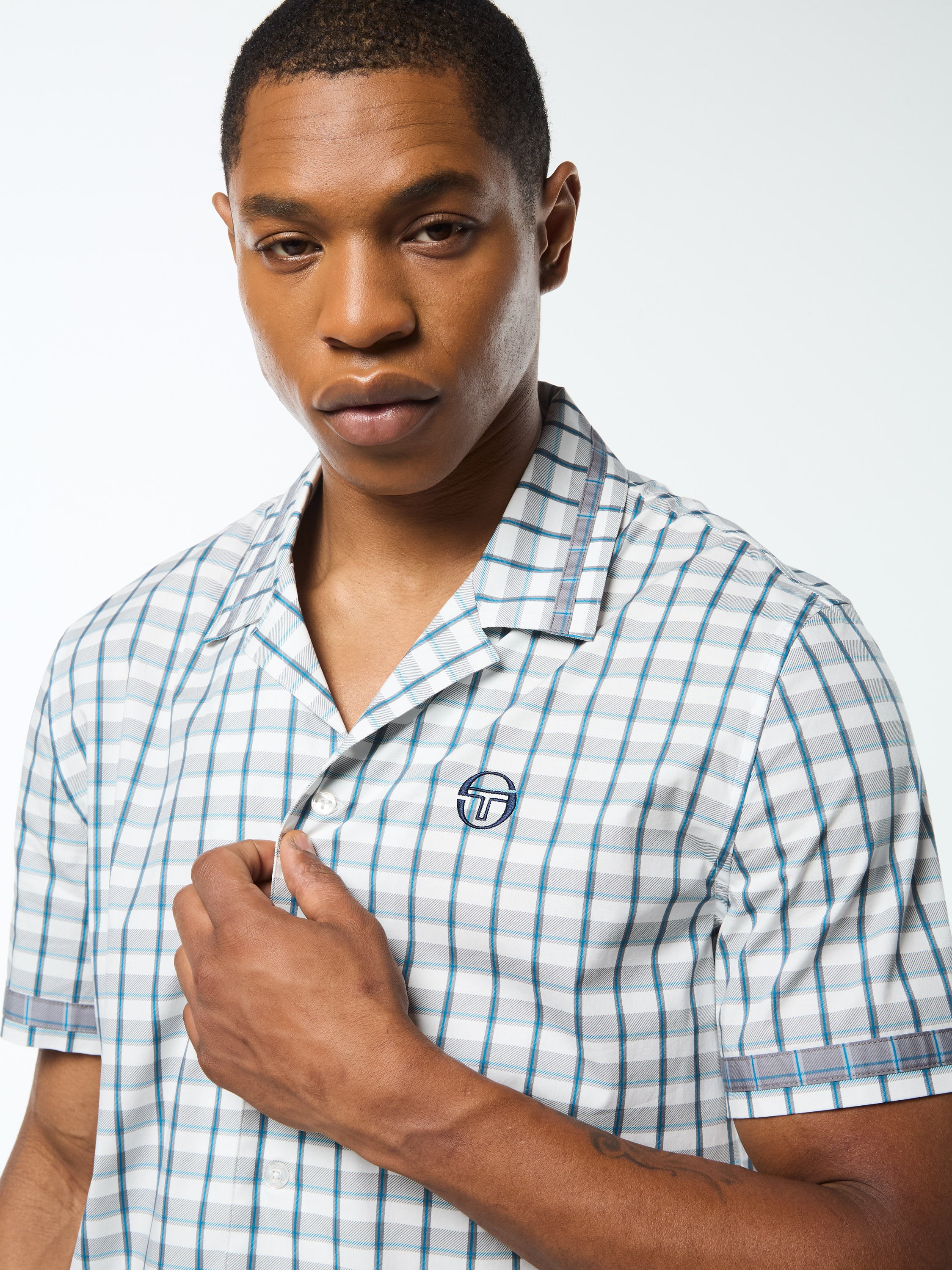 A man wearing a white plaid cabana shirt.