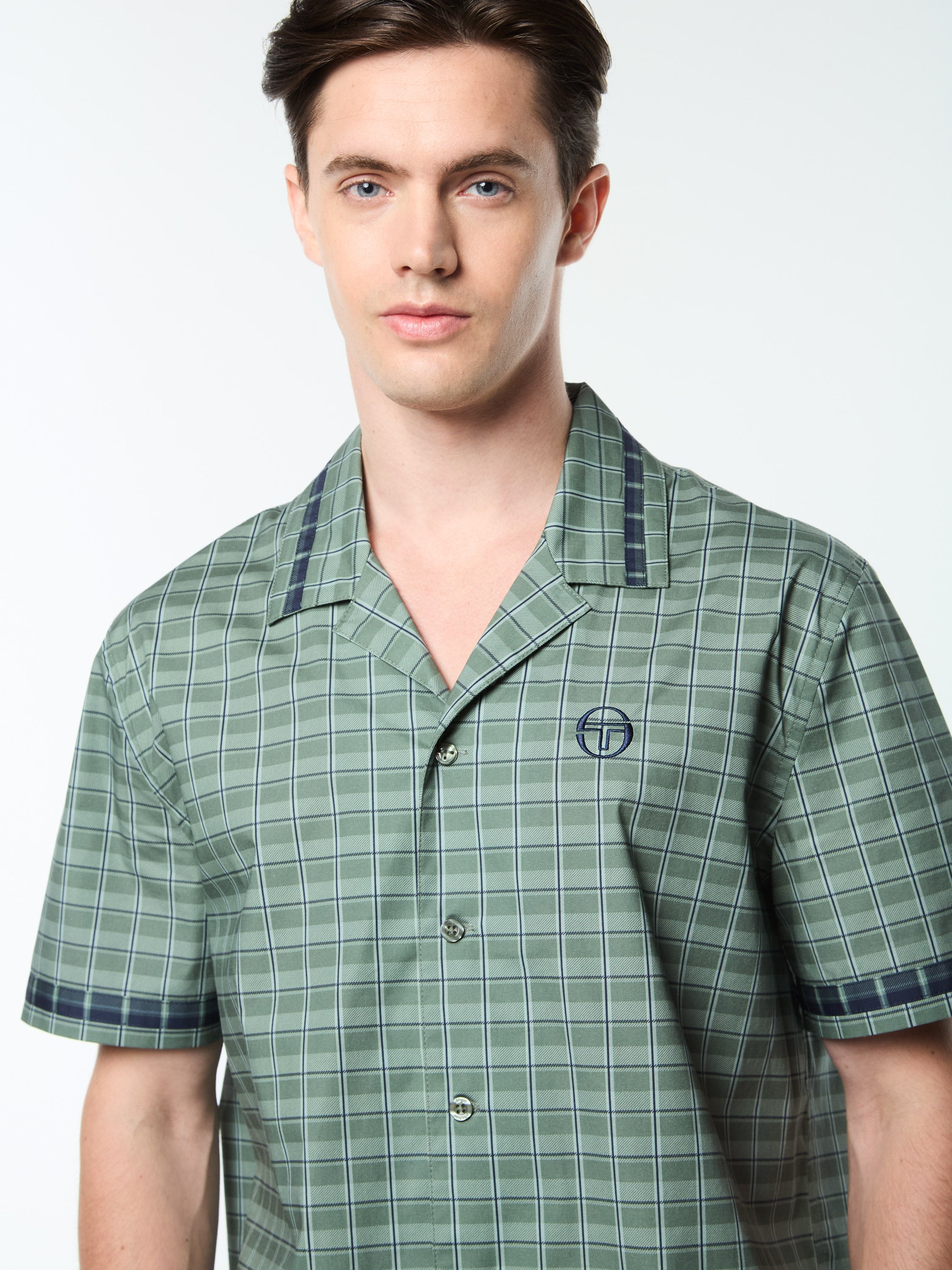 A man wearing a green plaid cabana shirt.