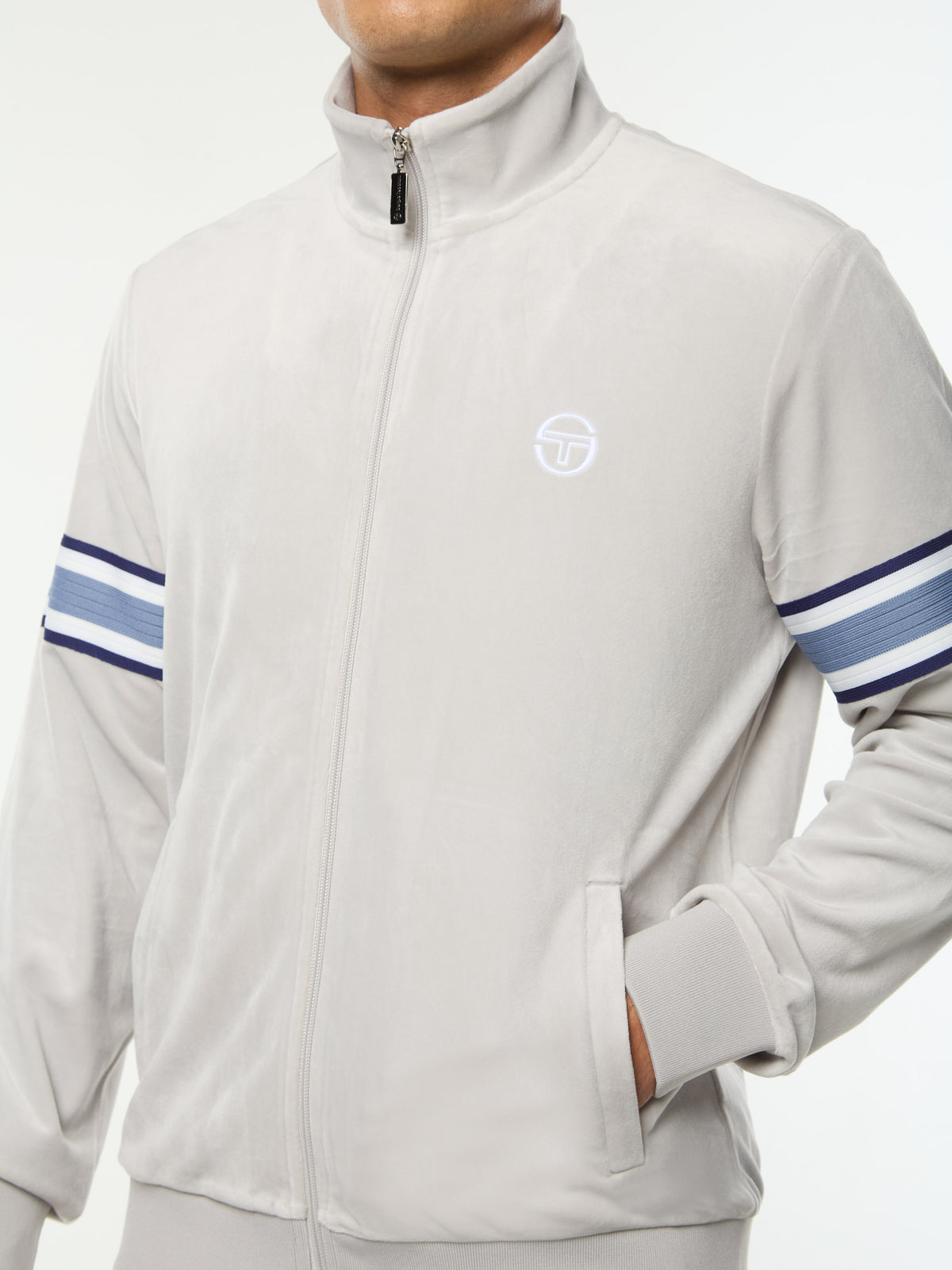 Close-up of the full zip, chest logo and sleeve stripe on the Linera Velour Track Jacket in Quiet Gray.