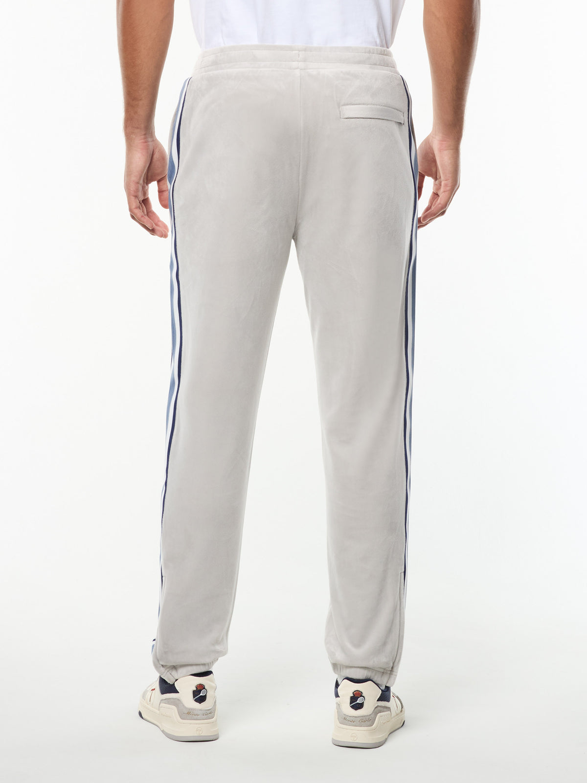 Back view of the Linera Velour Track Pant in Quiet Gray, showing the tapered fit and side stripes.