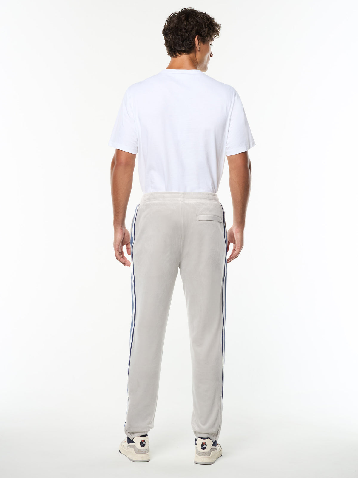 Full body back view of the Linera Velour Track Pant in Quiet Gray with a white tee.