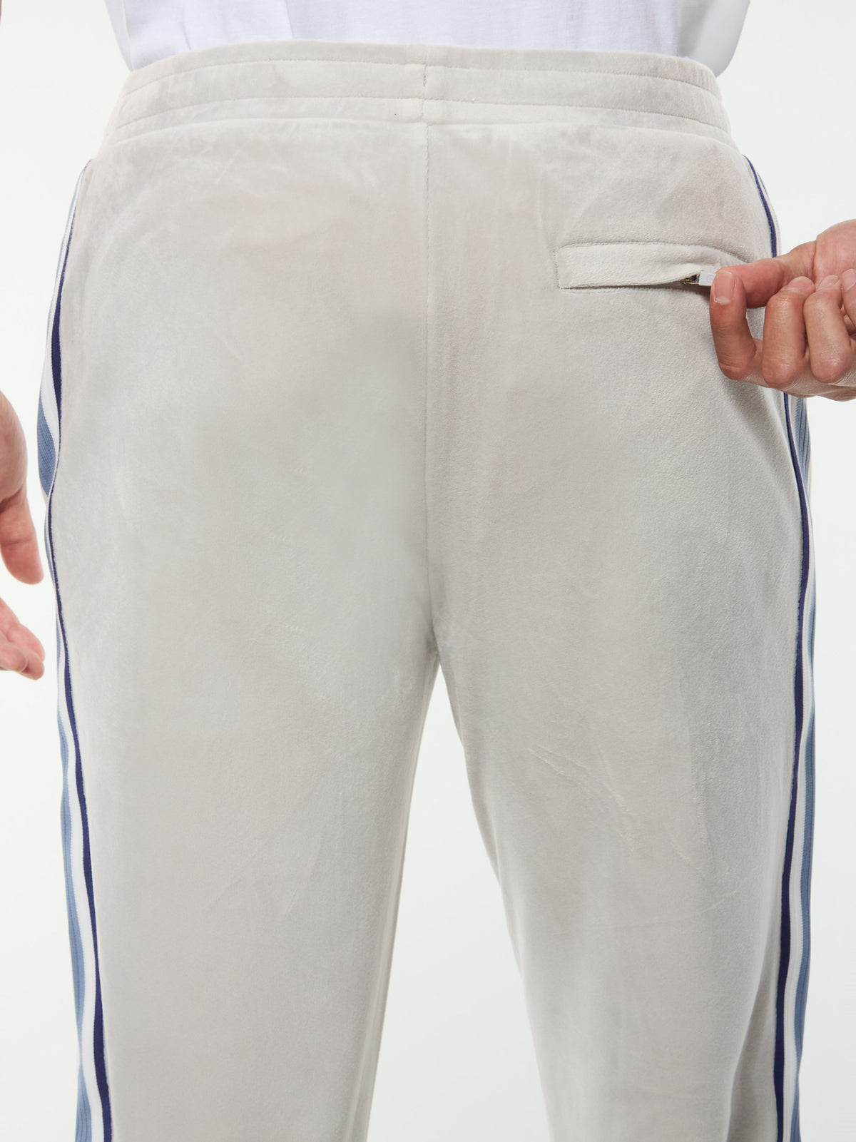 Close-up of the zip back pocket and velour texture on the Linera Velour Track Pant in Quiet Gray.