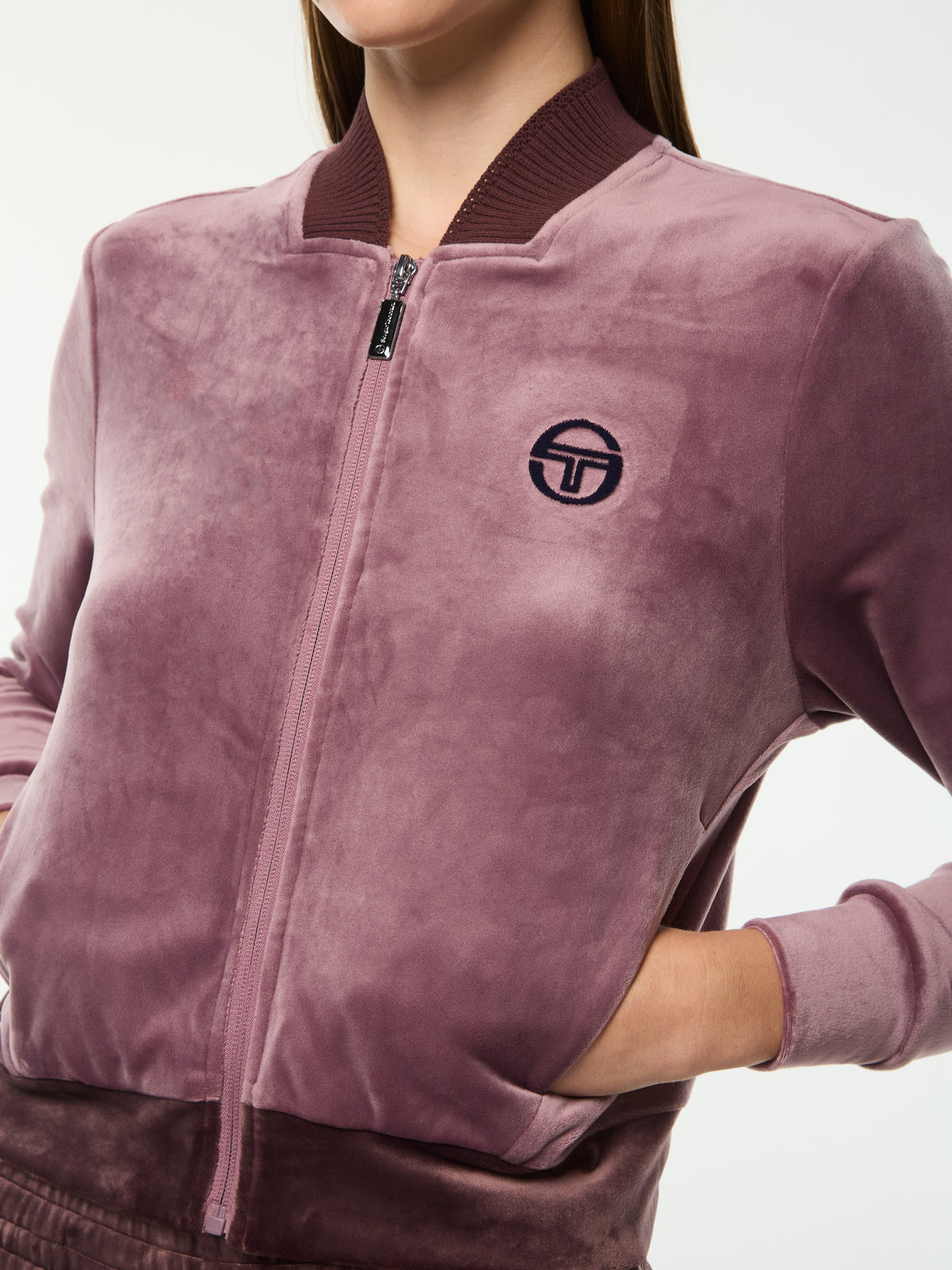 Close-up of the full zip, chest logo and ribbed hem on the Dalia Velour Track Jacket in Grape Shake.