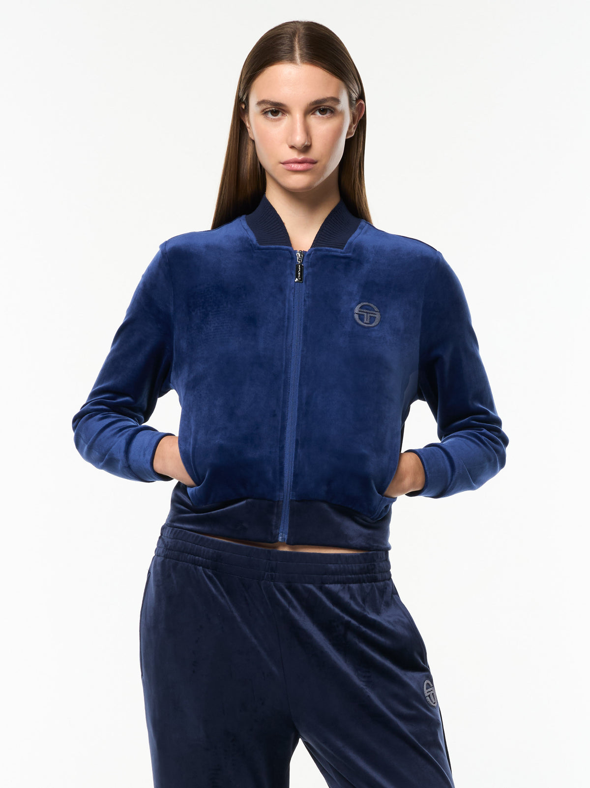 Model wearing the cropped Dalia Velour Track Jacket in Beacon Blue with matching velour pants, front upper body view.