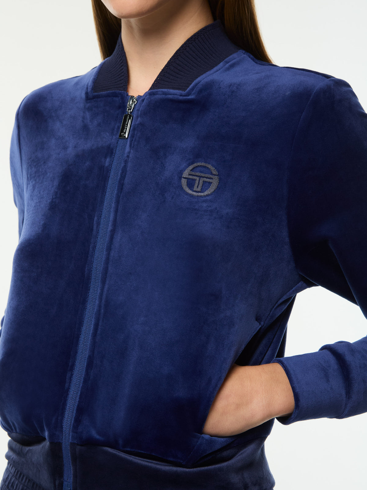 Close-up of the full zip, tonal chest logo and ribbed hem on the Dalia Velour Track Jacket in Beacon Blue.
