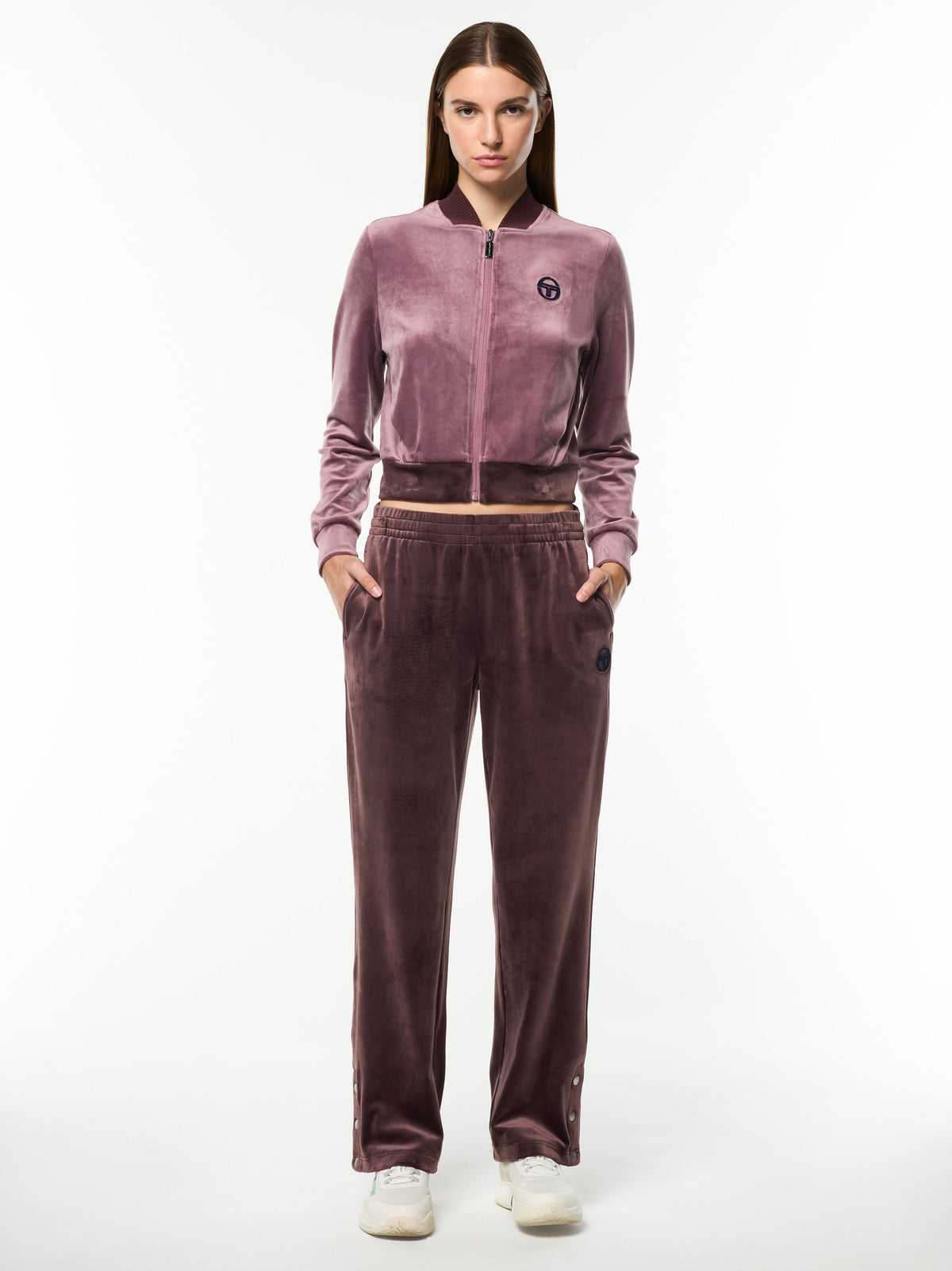 Model wearing the Dalia Velour Track Pant in Huckleberry with a cropped Grape Shake velour jacket, full body front view.