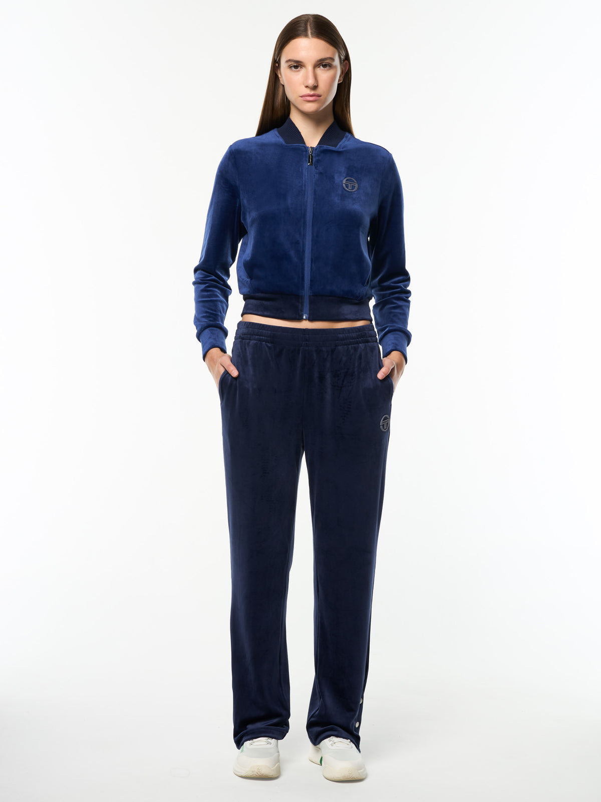 Model wearing the Dalia Velour Track Pant in Maritime Blue with a matching cropped velour jacket, full body front view.
