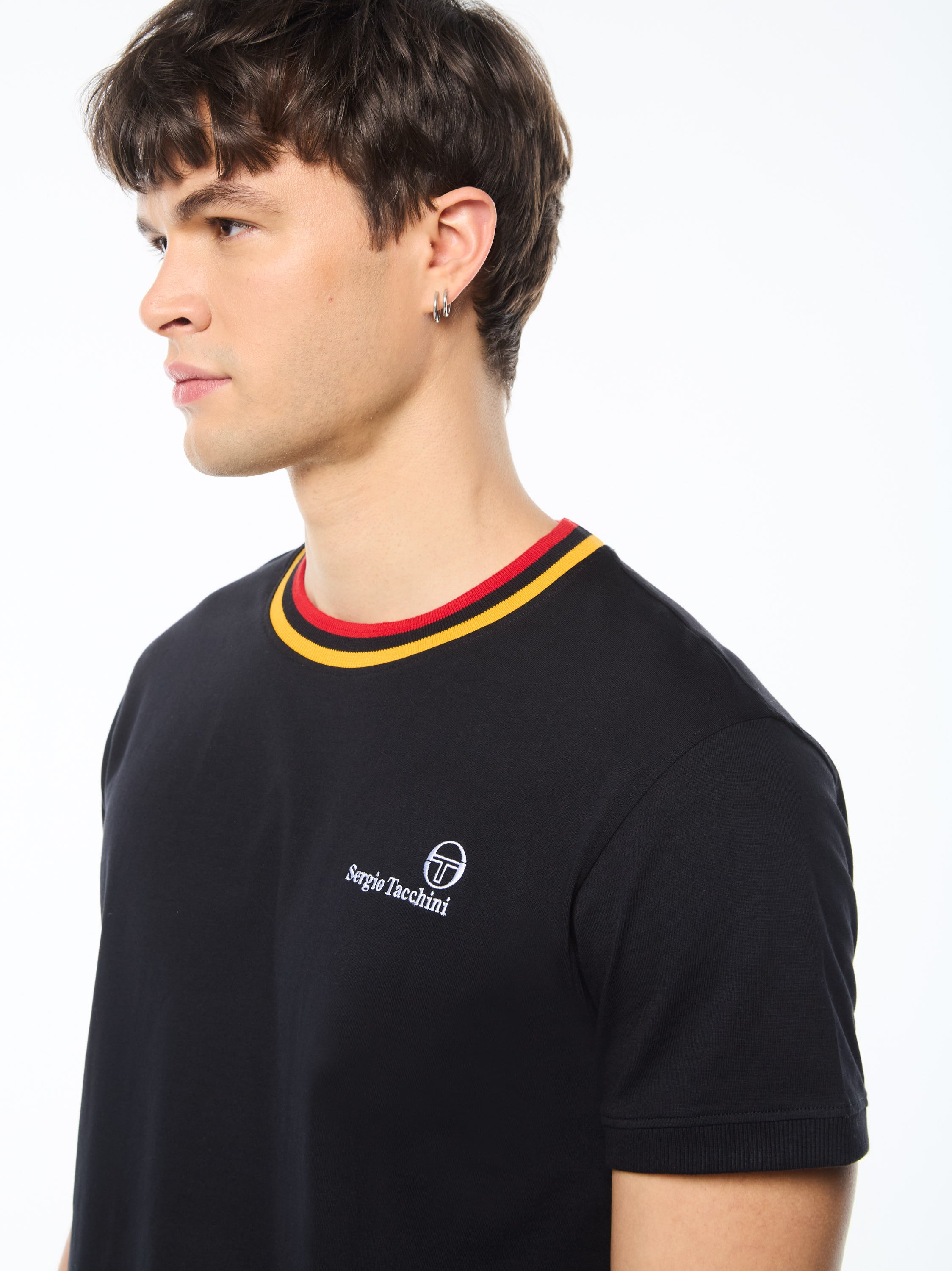 Man wearing a black shirt with a red and yellow stripe around collar.