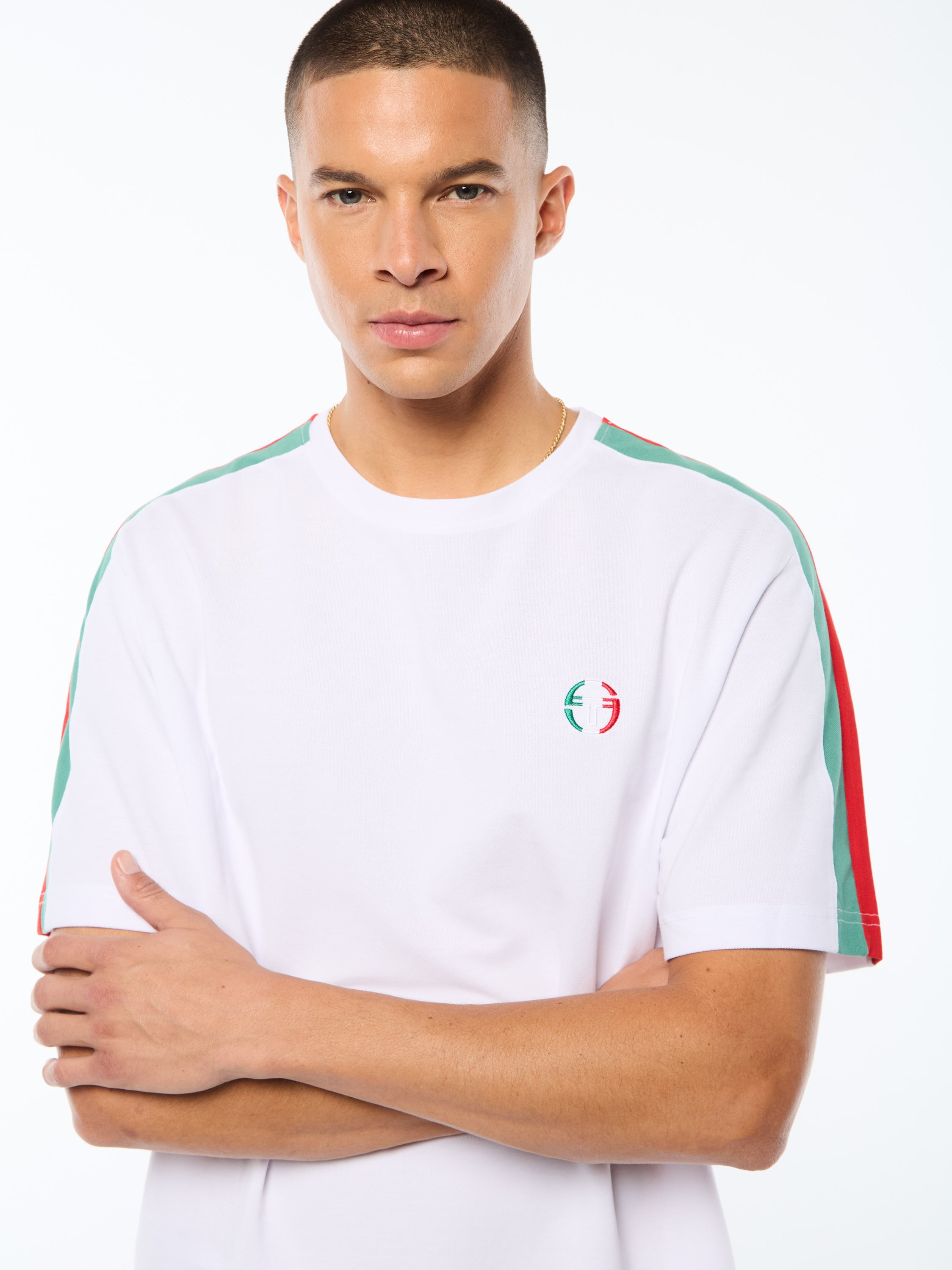Man wearing a white t-shirt with red and green accent details.