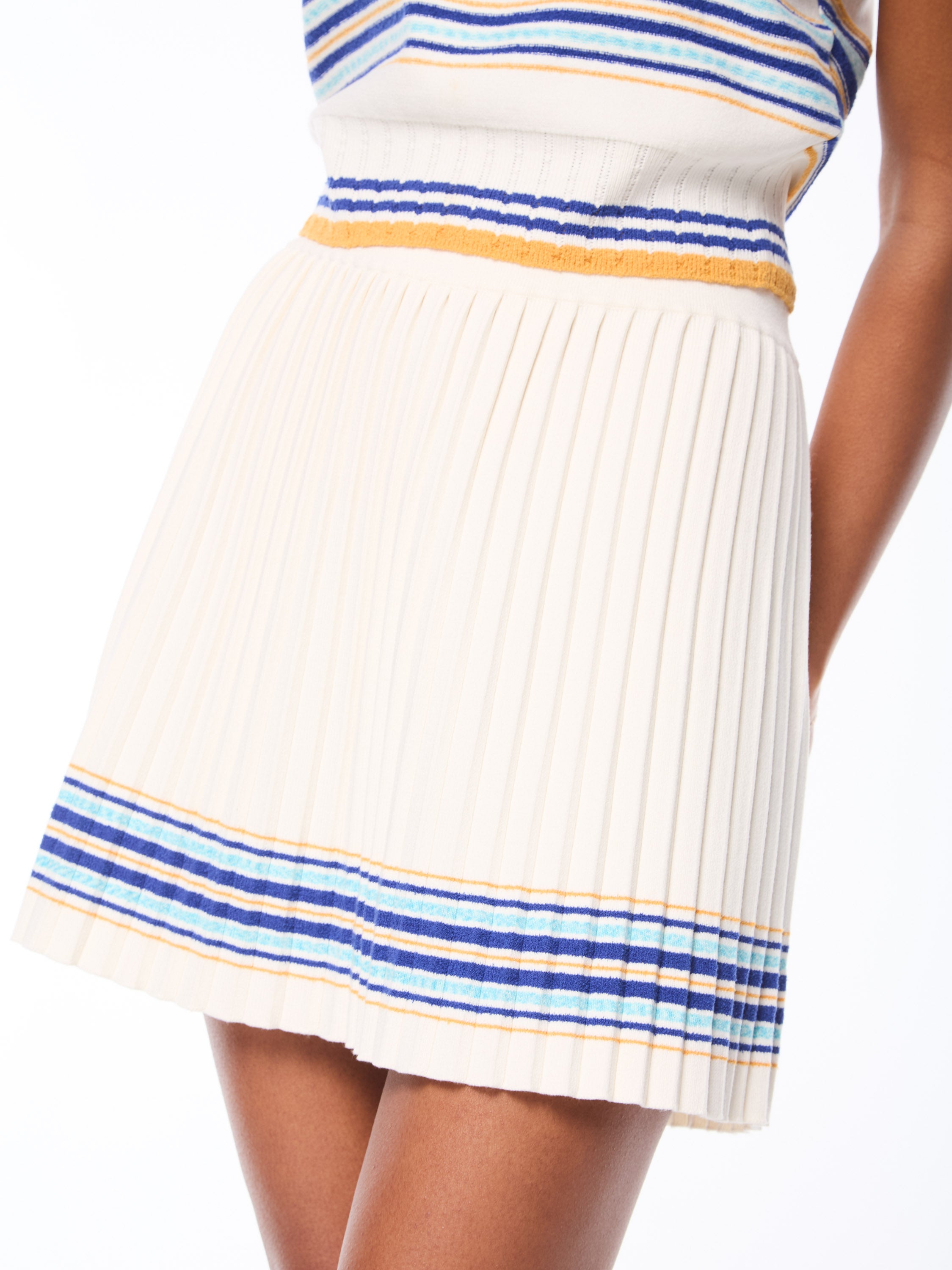 Woman wearing a knit pleated skirt with stripes.