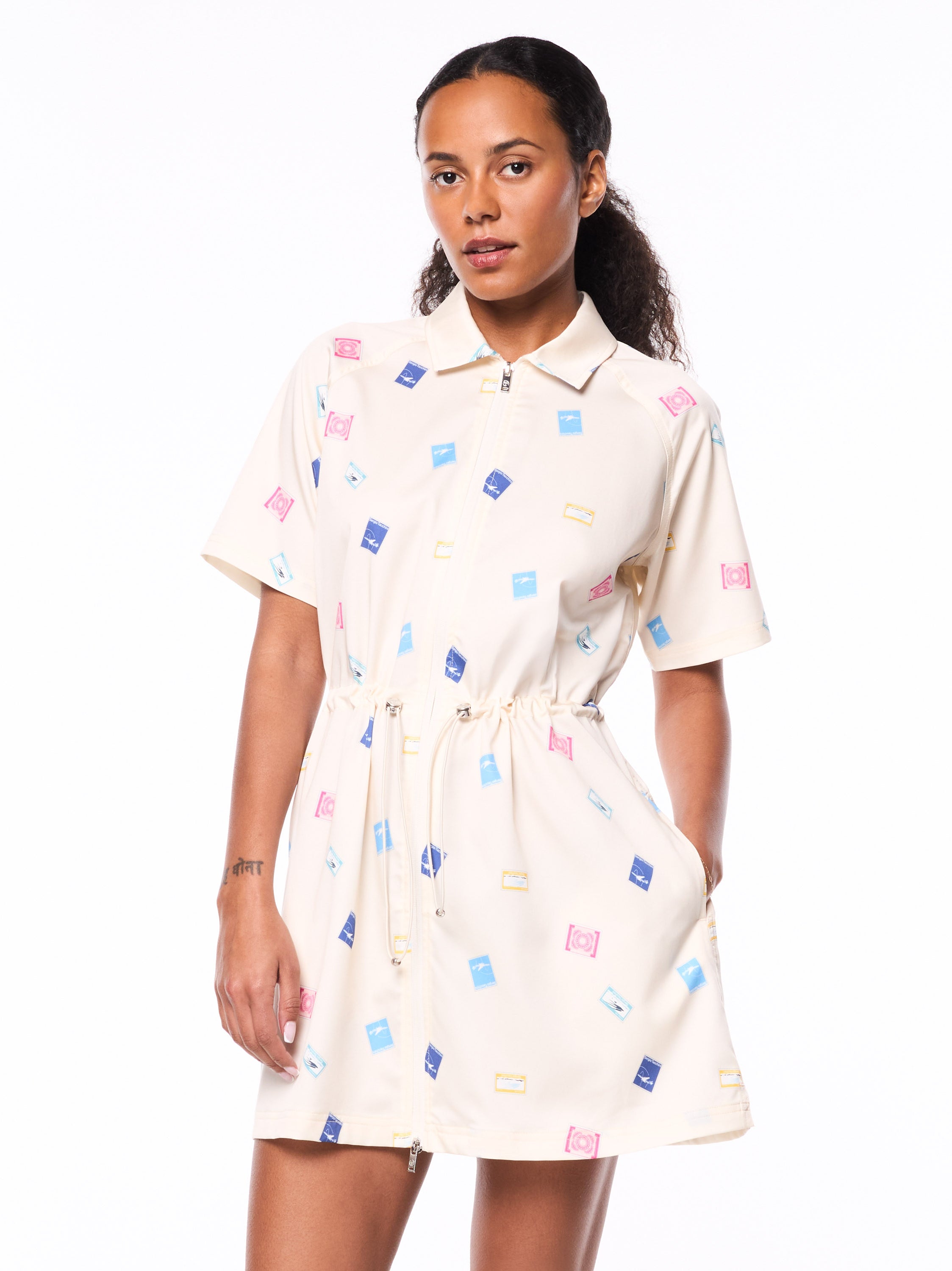 Woman wearing a white dress withshort sleeves and a colorful print.