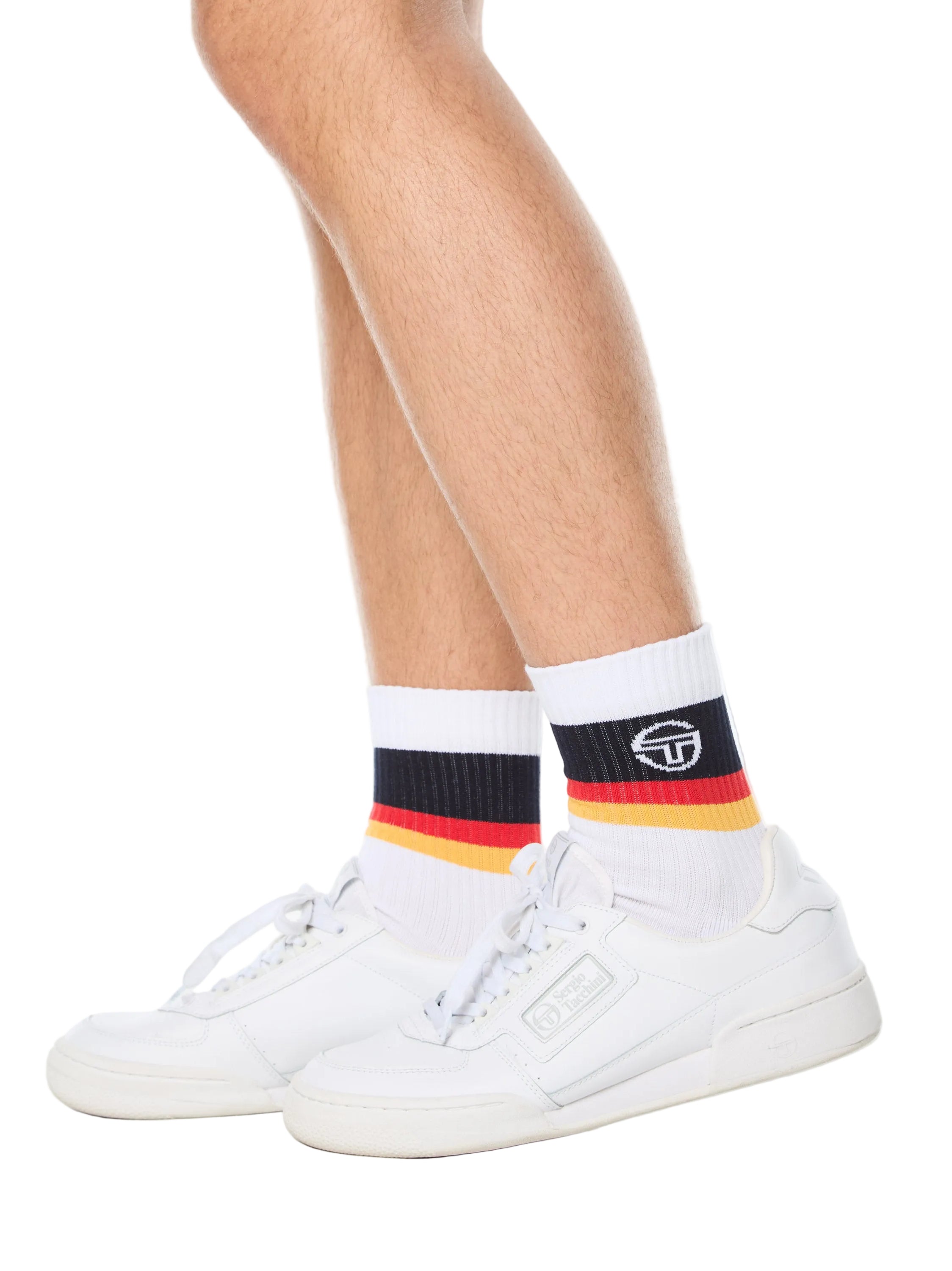 Man wearing white socks with black, red, and yellow stripes.