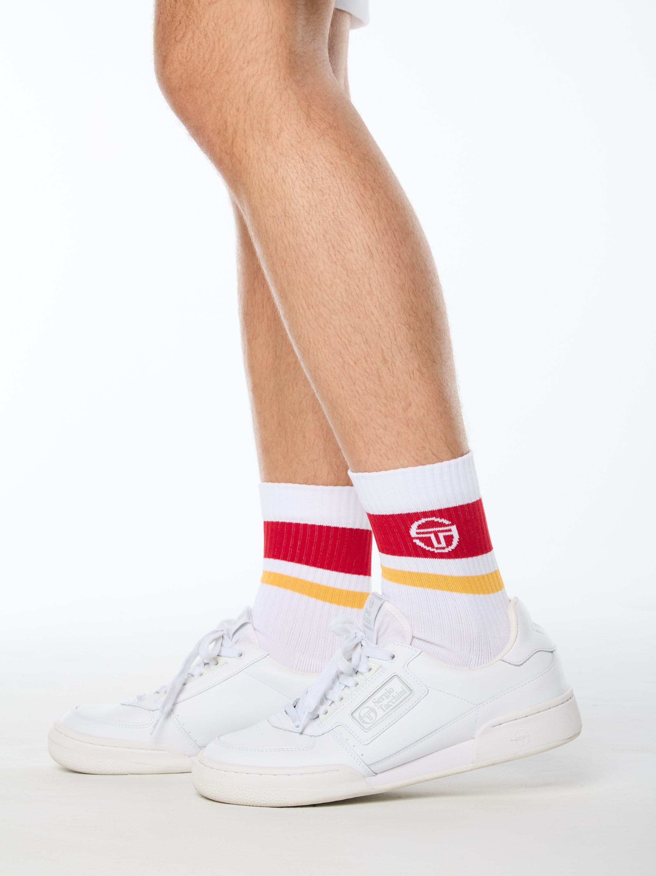 Man wearing white socks with red and yellow stripes.