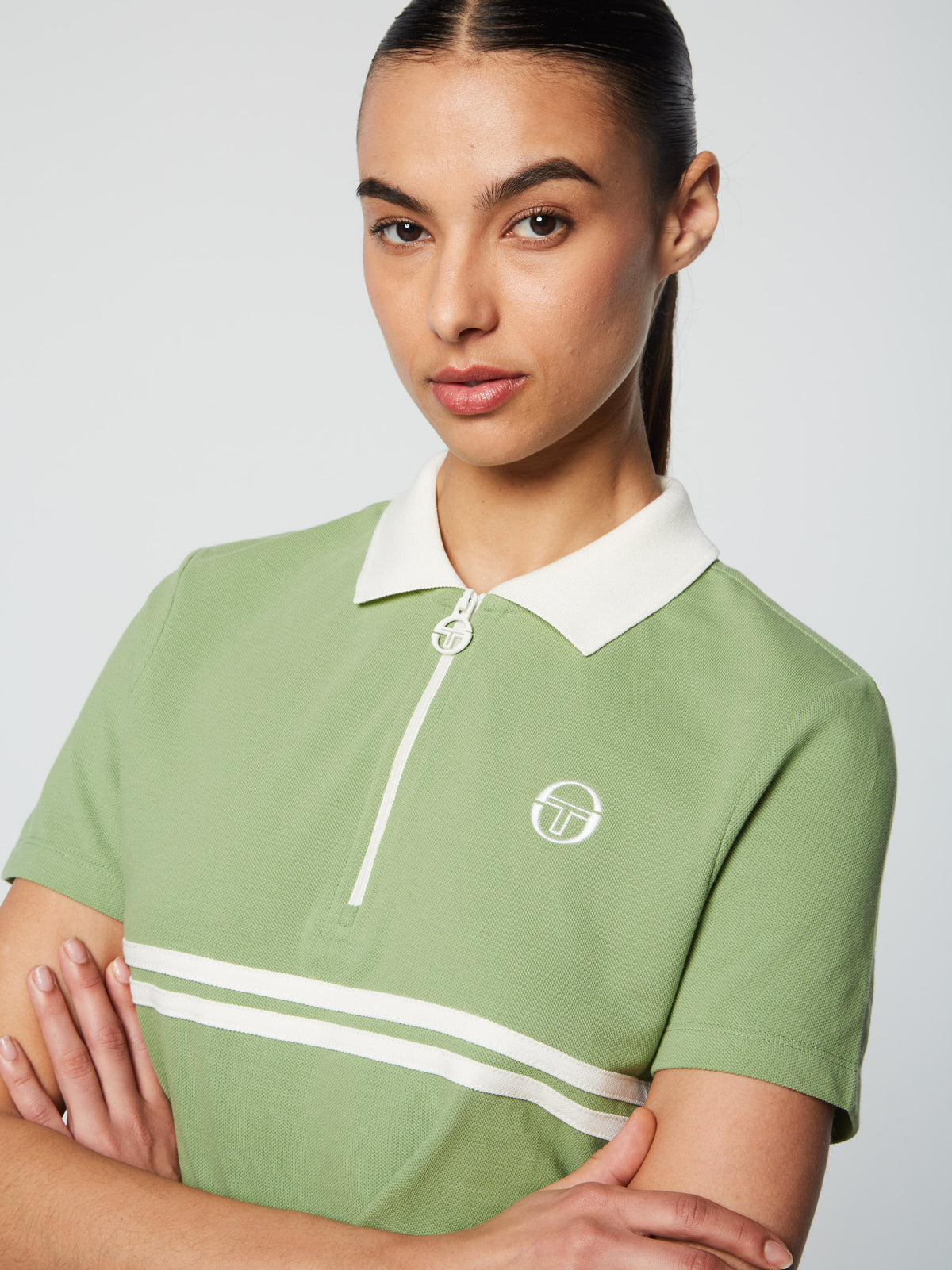 Close-up of the white collar, half-zip placket, and chest stripe on the Miss Supermac Polo in Jade Green.