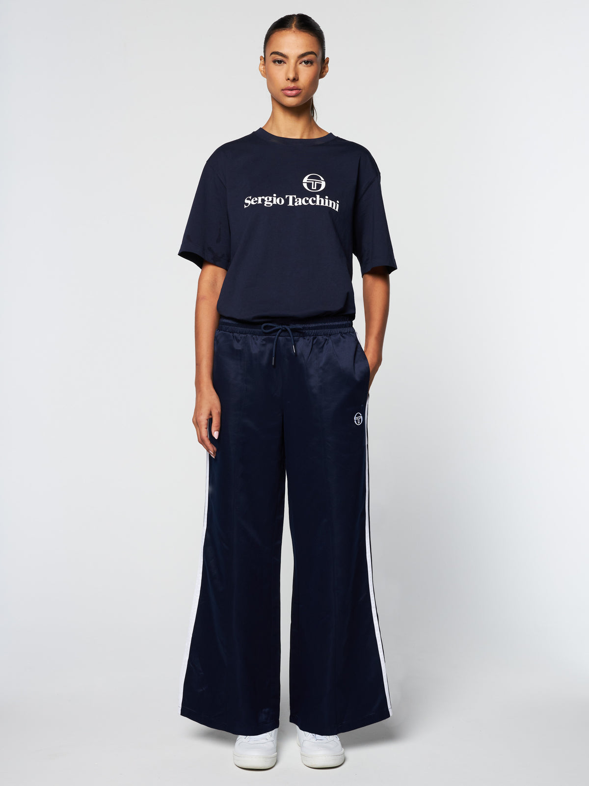 Model wearing the Miss Stella Pants in Maritime Blue with a Sergio Tacchini graphic t-shirt.