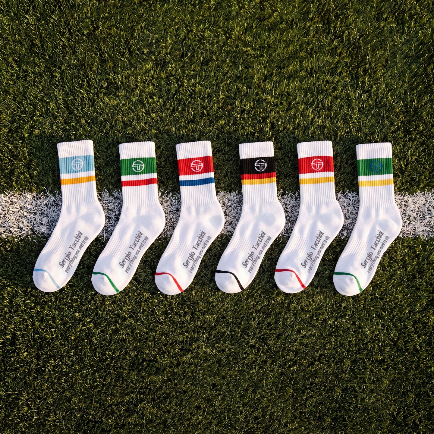 Multi colored socks laying on a soccer field.