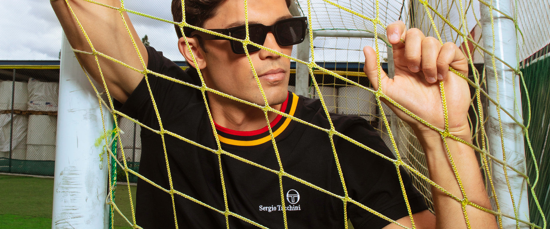 Man standing inside soccer net.