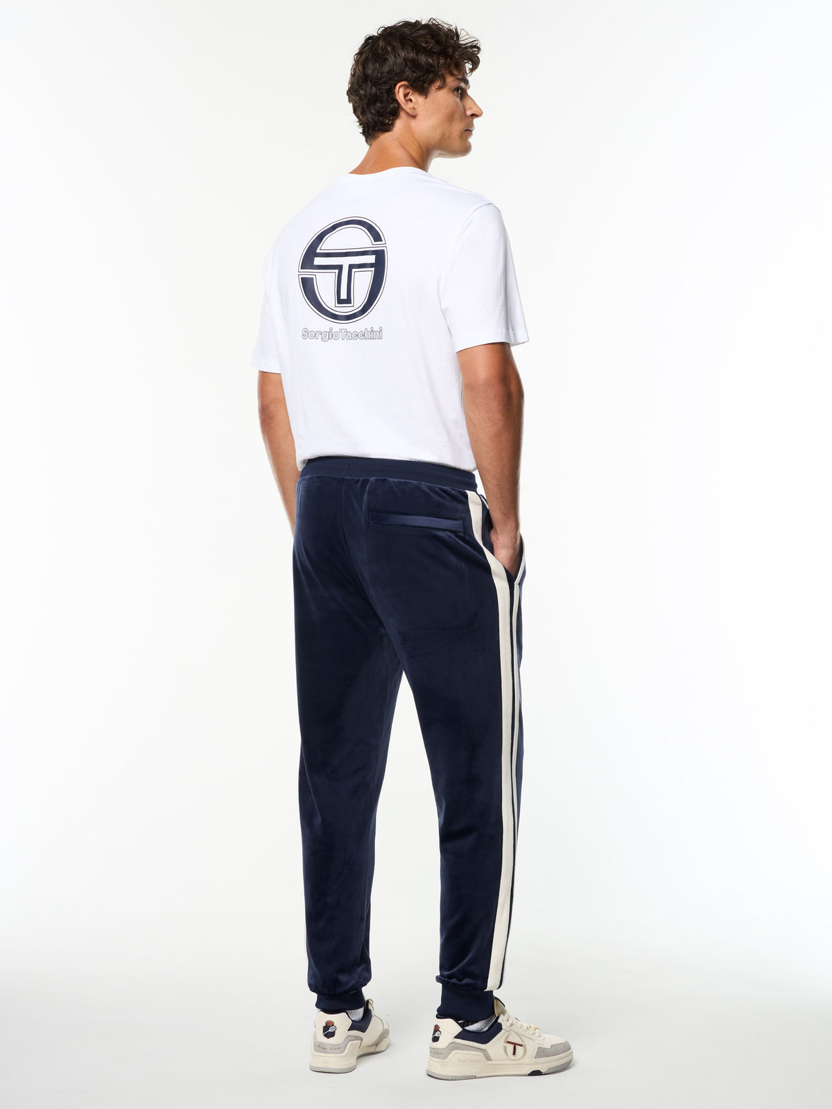 Full body back view of the Damarindo Velour Track Pant in Maritime Blue with a white Sergio Tacchini logo tee.