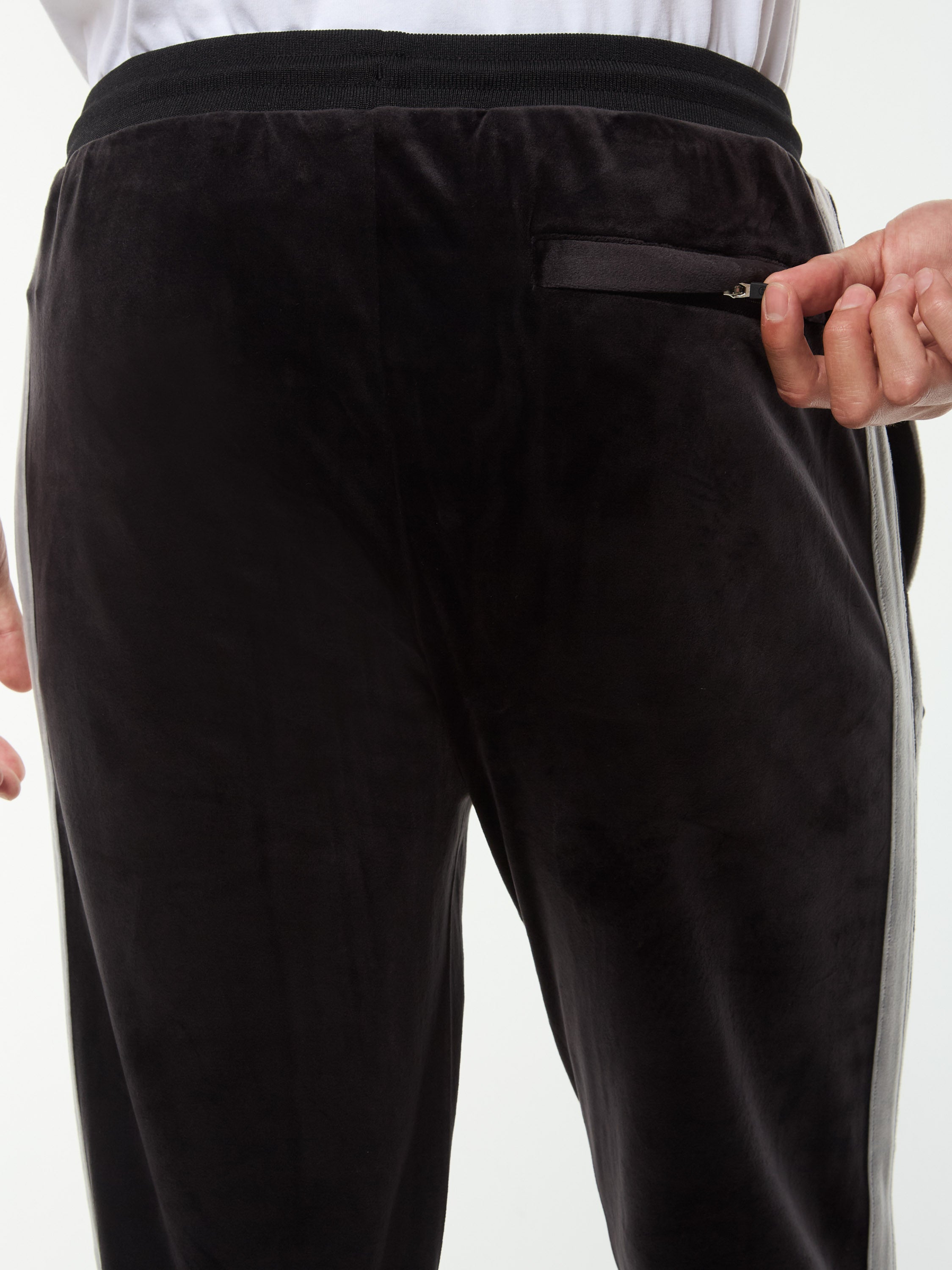 Close-up of the zip back pocket and velour texture on the Damarindo Velour Track Pant in Black Beauty.