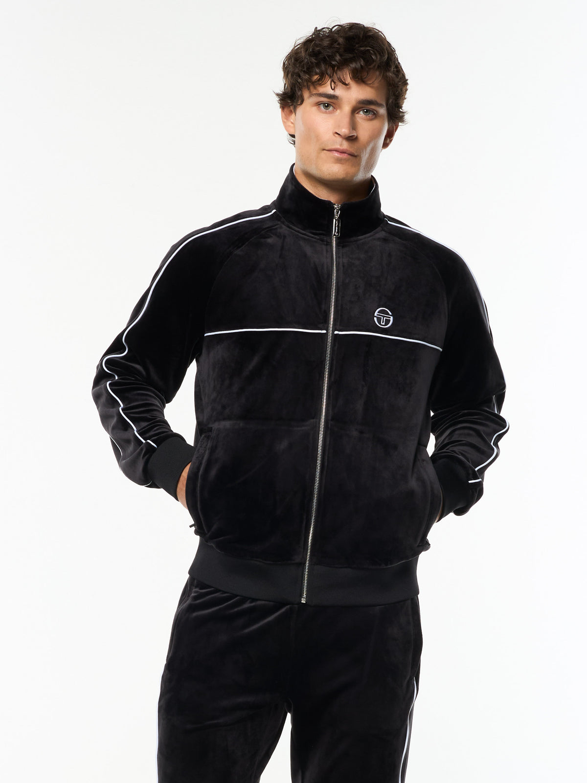 Model wearing the Lioni Velour Track Jacket in Black Beauty with white piping, front upper body view.