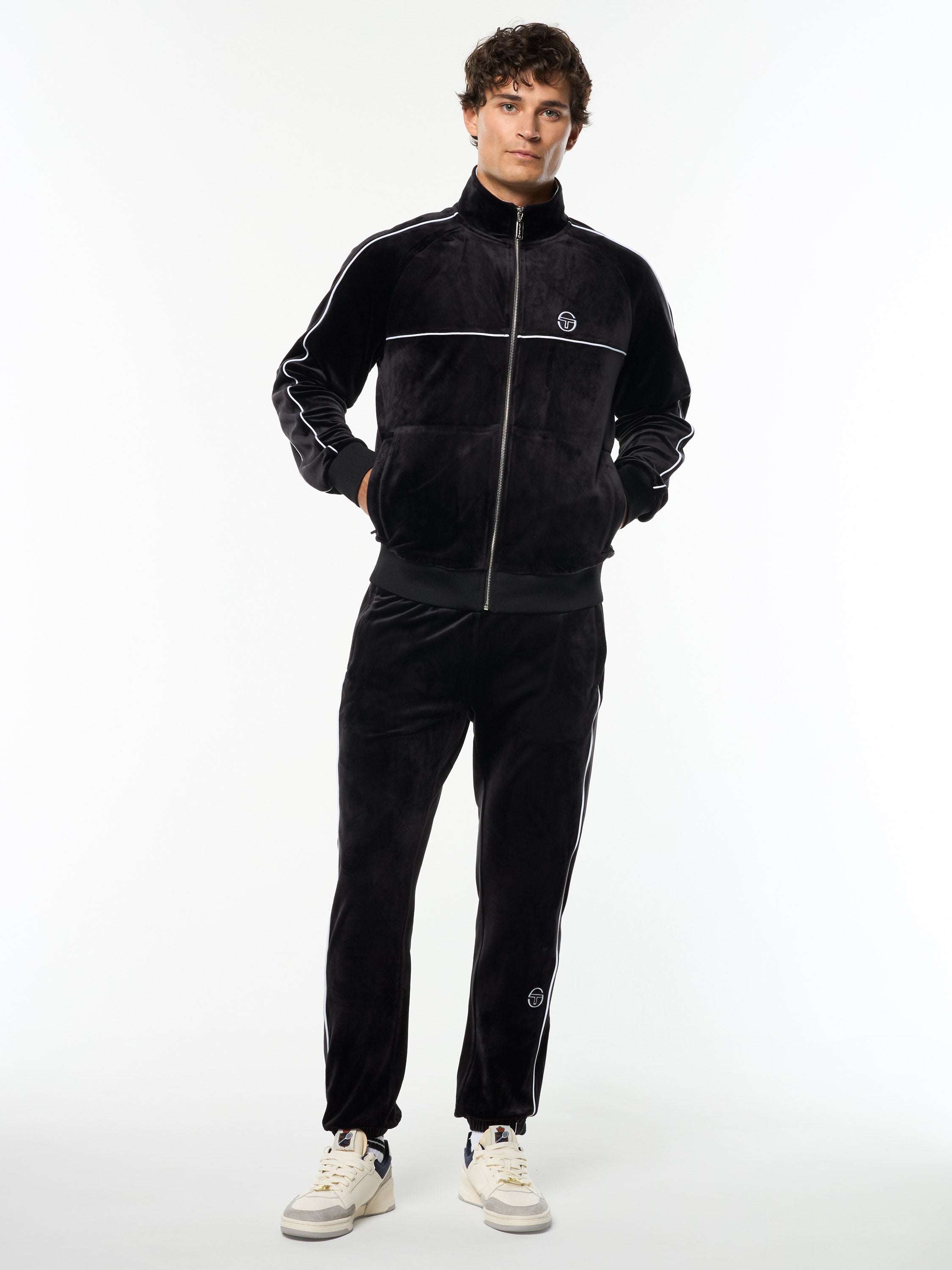 Model wearing the Lioni Velour Track Jacket in Black Beauty with matching velour pants, full body front view.