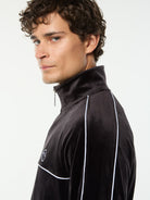 Side profile close-up of the stand collar and piping on the Lioni Velour Track Jacket in Black Beauty.