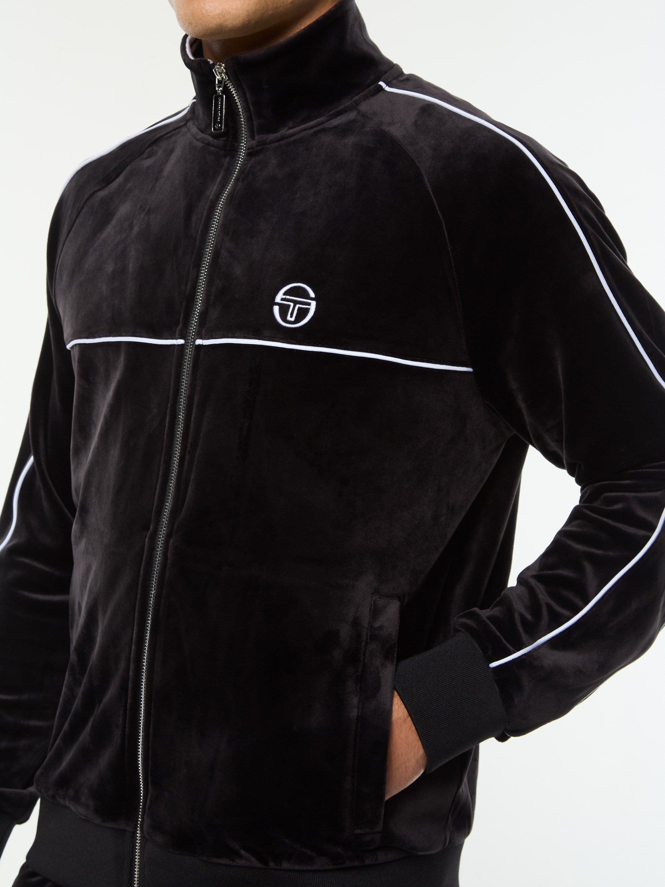 Close-up of the chest logo, zip and piping on the Lioni Velour Track Jacket in Black Beauty.