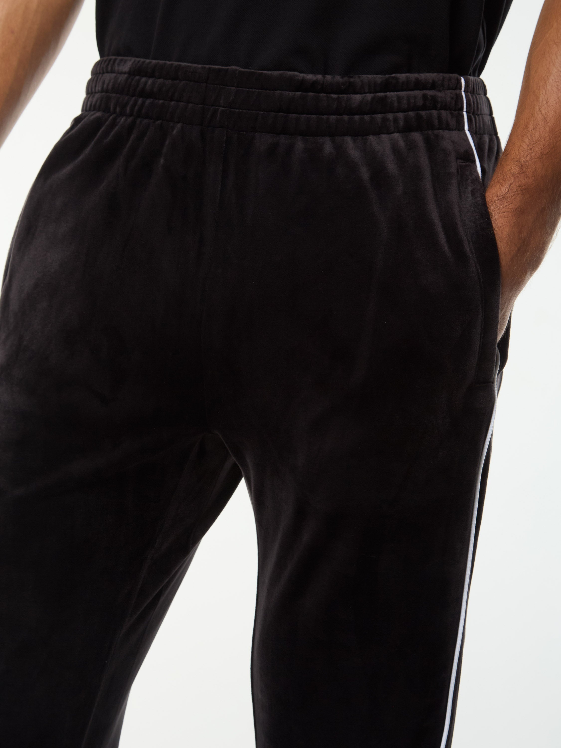 Close-up of the elastic waistband and side piping on the Lioni Velour Track Pant in Black Beauty.