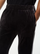 Close-up of the elastic waistband and side piping on the Lioni Velour Track Pant in Black Beauty.