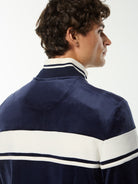 Close-up back view of the collar and white stripe on the Damarindo Velour Track Jacket in Maritime Blue.