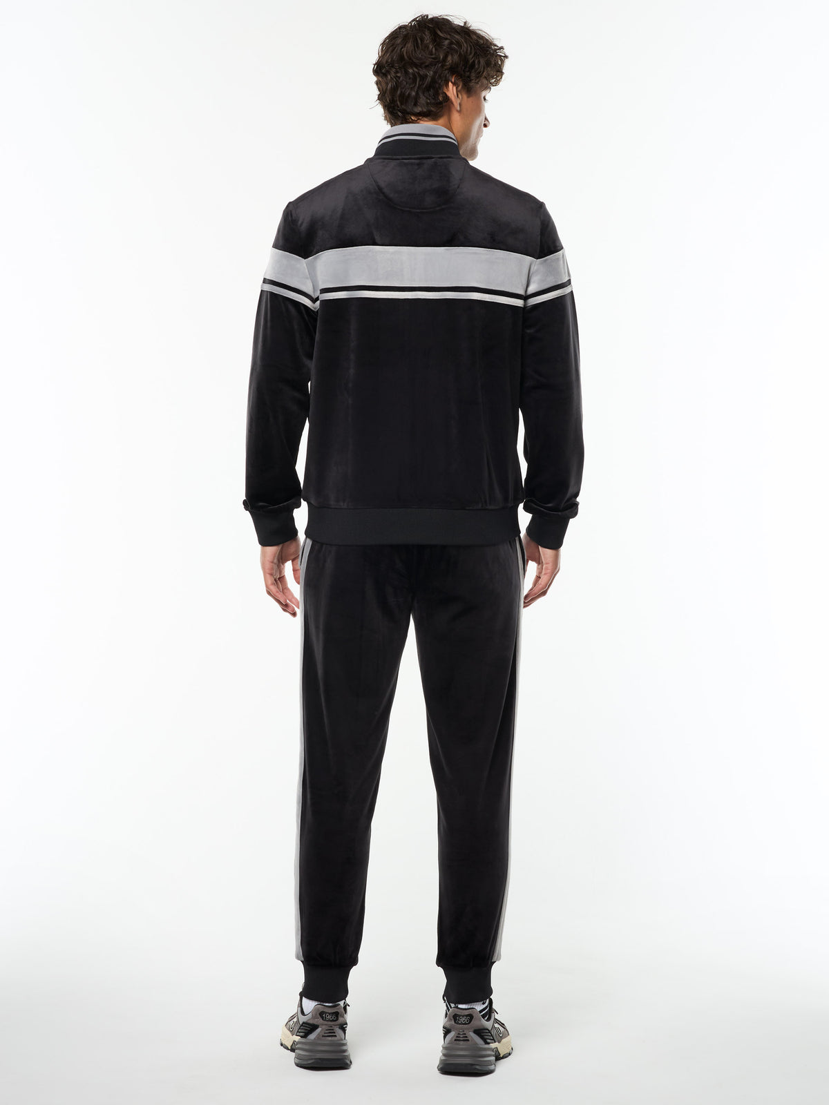 Full body back view of the Damarindo Velour Track Jacket and matching pants in Black Beauty.