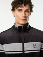 Close-up front portrait of the stand collar and embroidered logo on the Damarindo Velour Track Jacket in Black Beauty.
